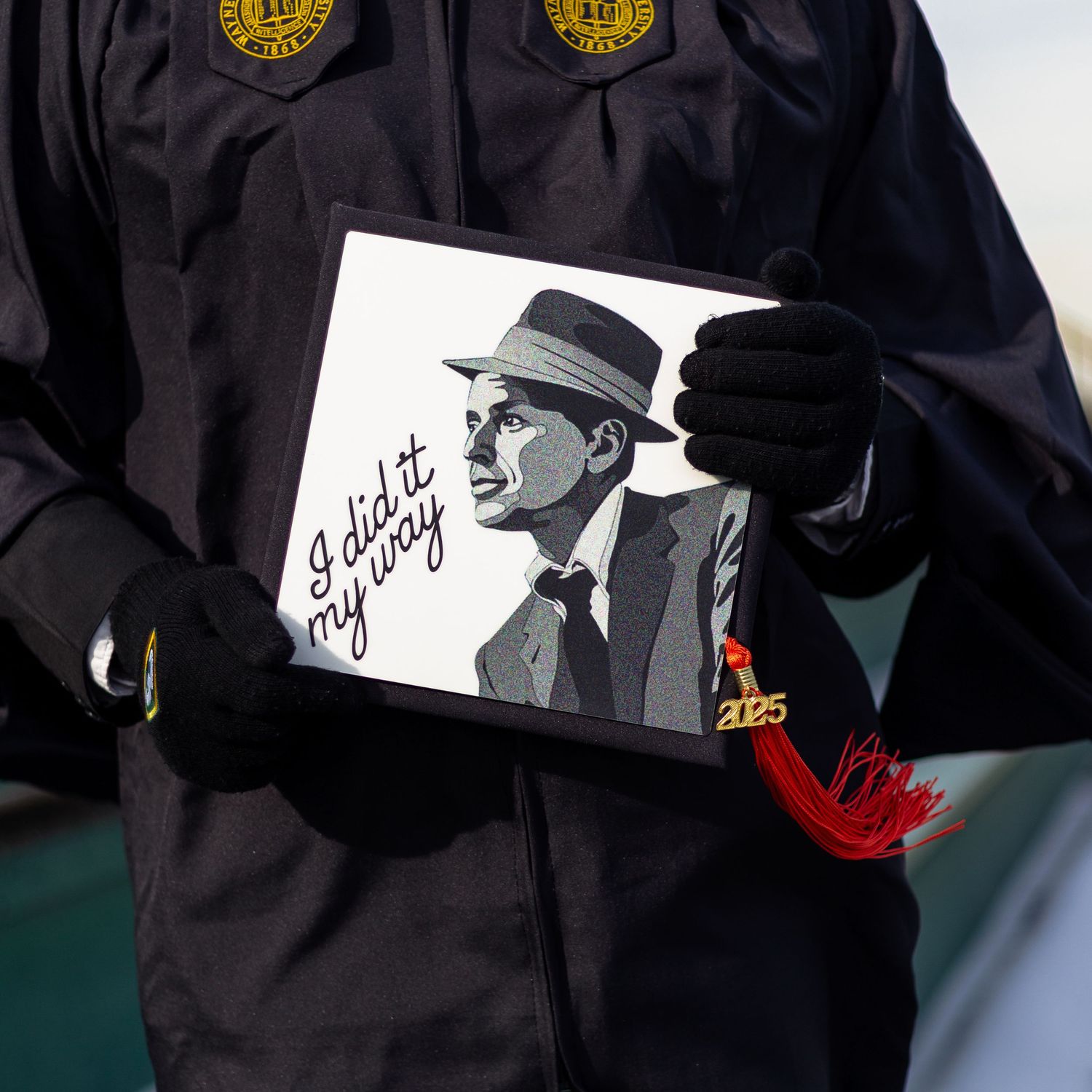 Wayne State graduate holds a Frank Sinatra graduation cap with I did it my way quote.