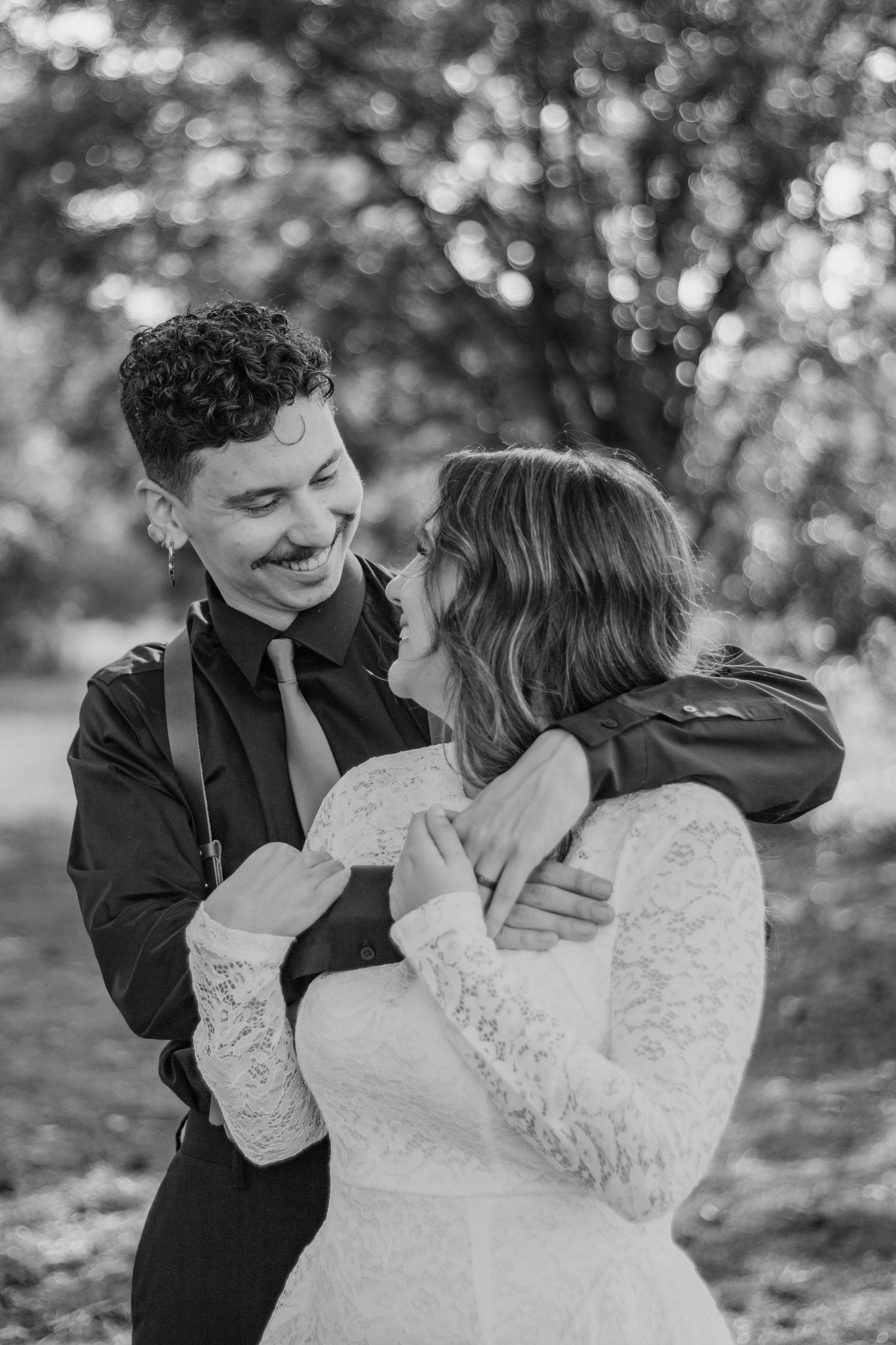 A romantic black and white photo sequence showing a couple in wedding attire embracing in a wooded outdoor setting.