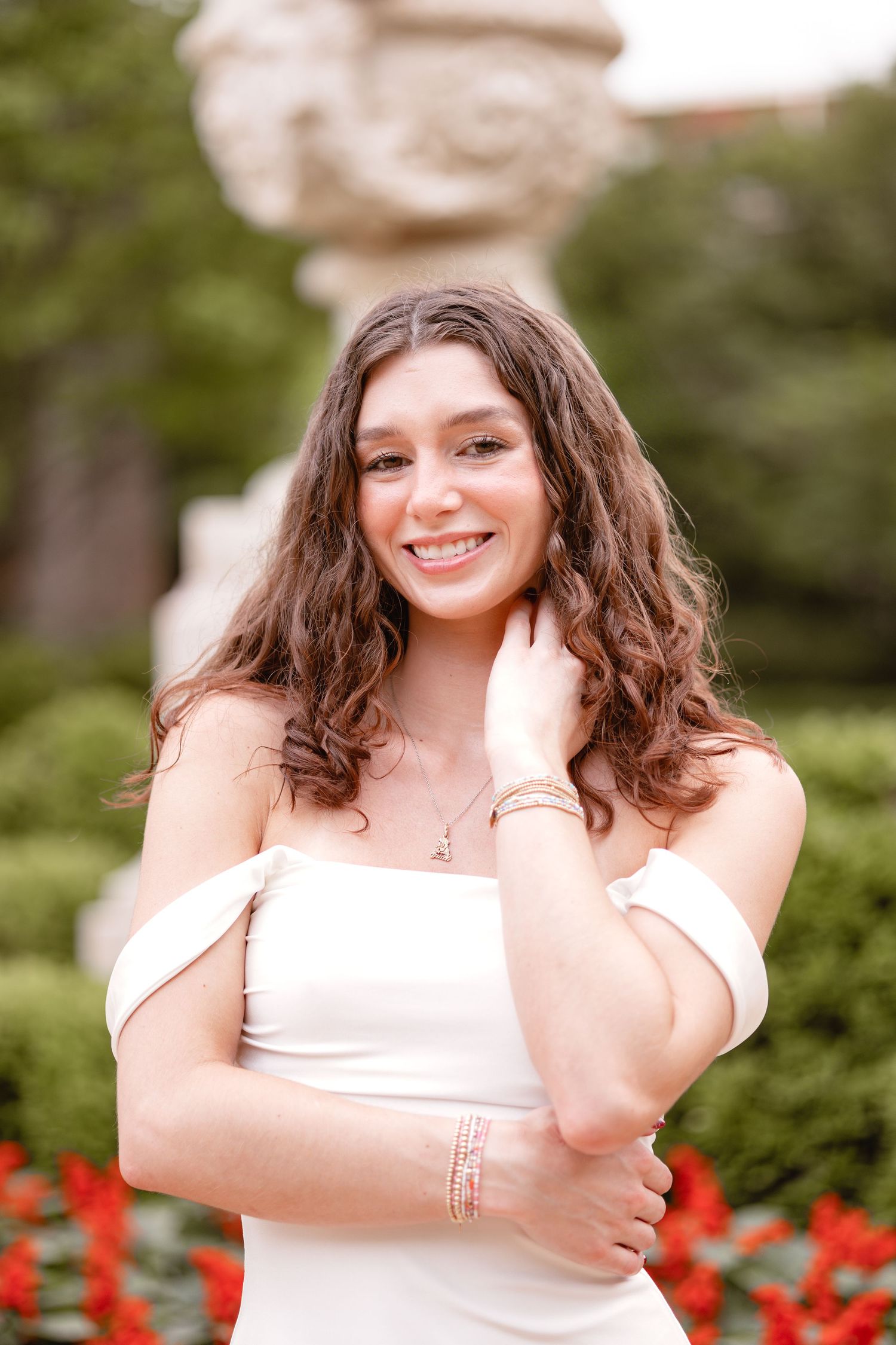 A series of joyful portraits in a garden setting with vibrant red flowers in the background.