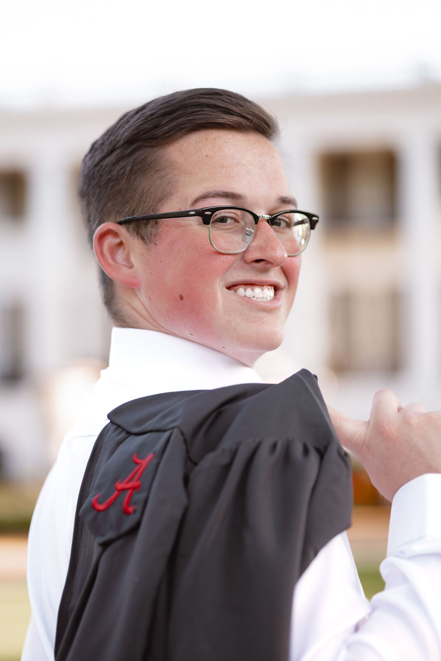 A person wearing glasses and a black graduation gown shown from different angles in a multi-panel photo series.