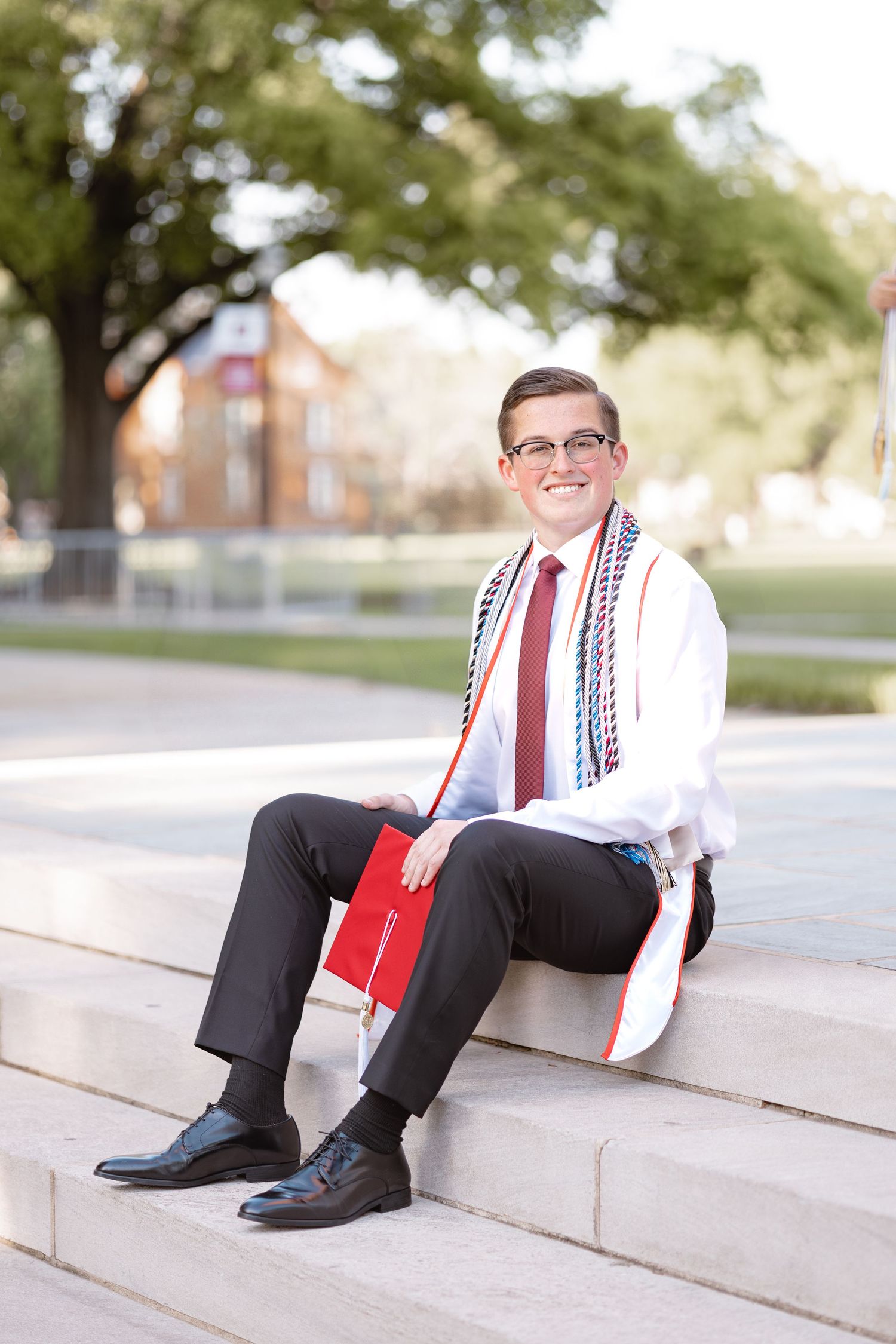 Graduation photos showing a graduate in formal attire posing on concrete steps outdoors.