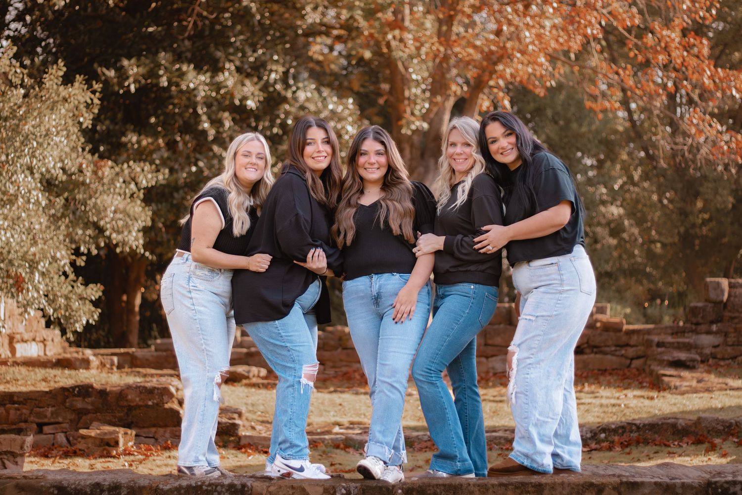 A casual salon photoshoot outdoors with everyone wearing denim and black shirts.