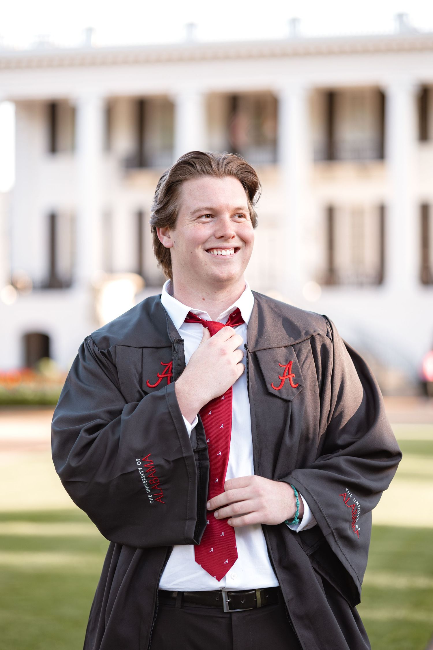 Series of photos showing a joyful emotional expression while wearing a suit and red tie outdoors.