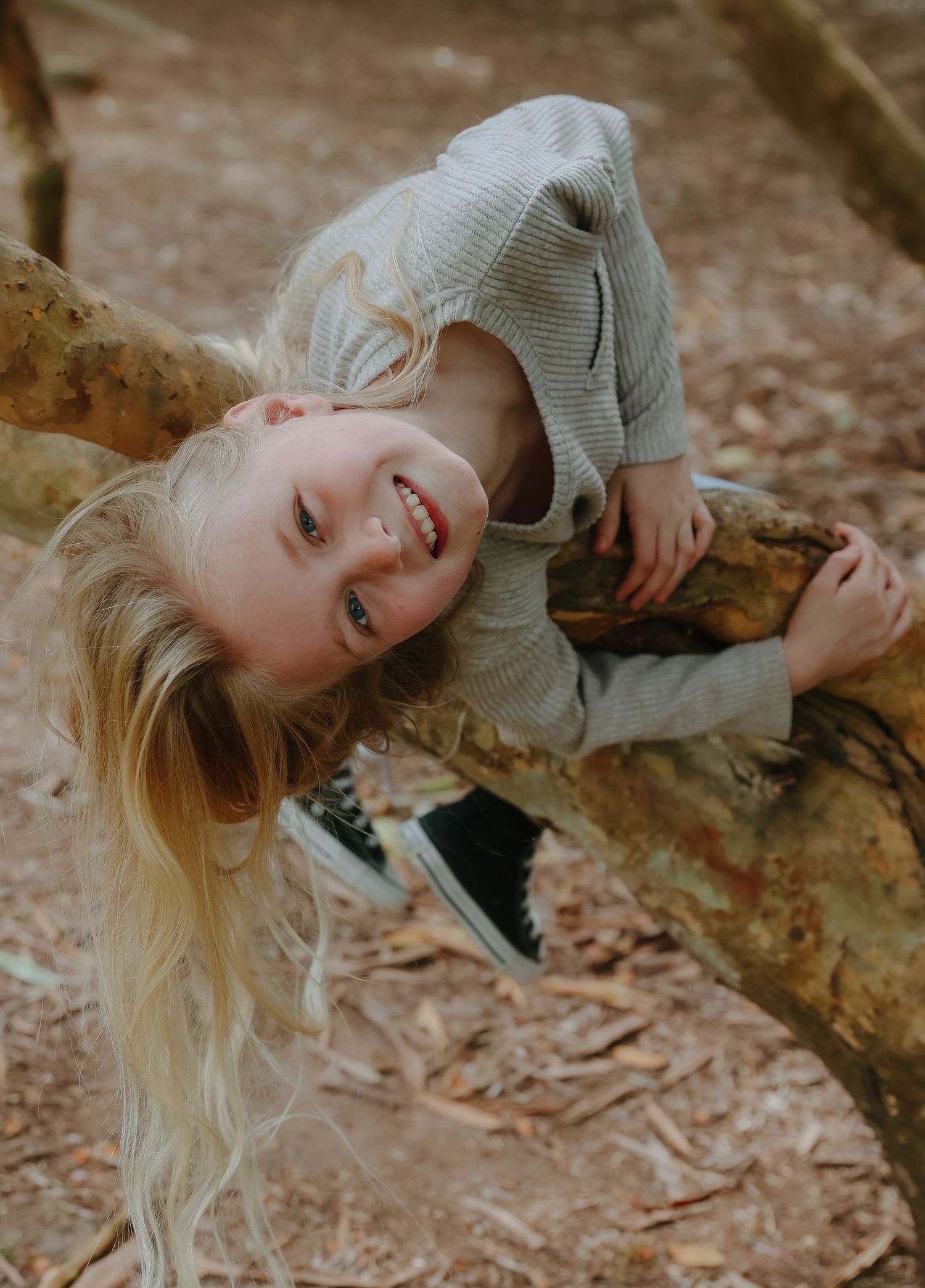 Playful portrait series of person laying on rocky surface with fall leaves around.