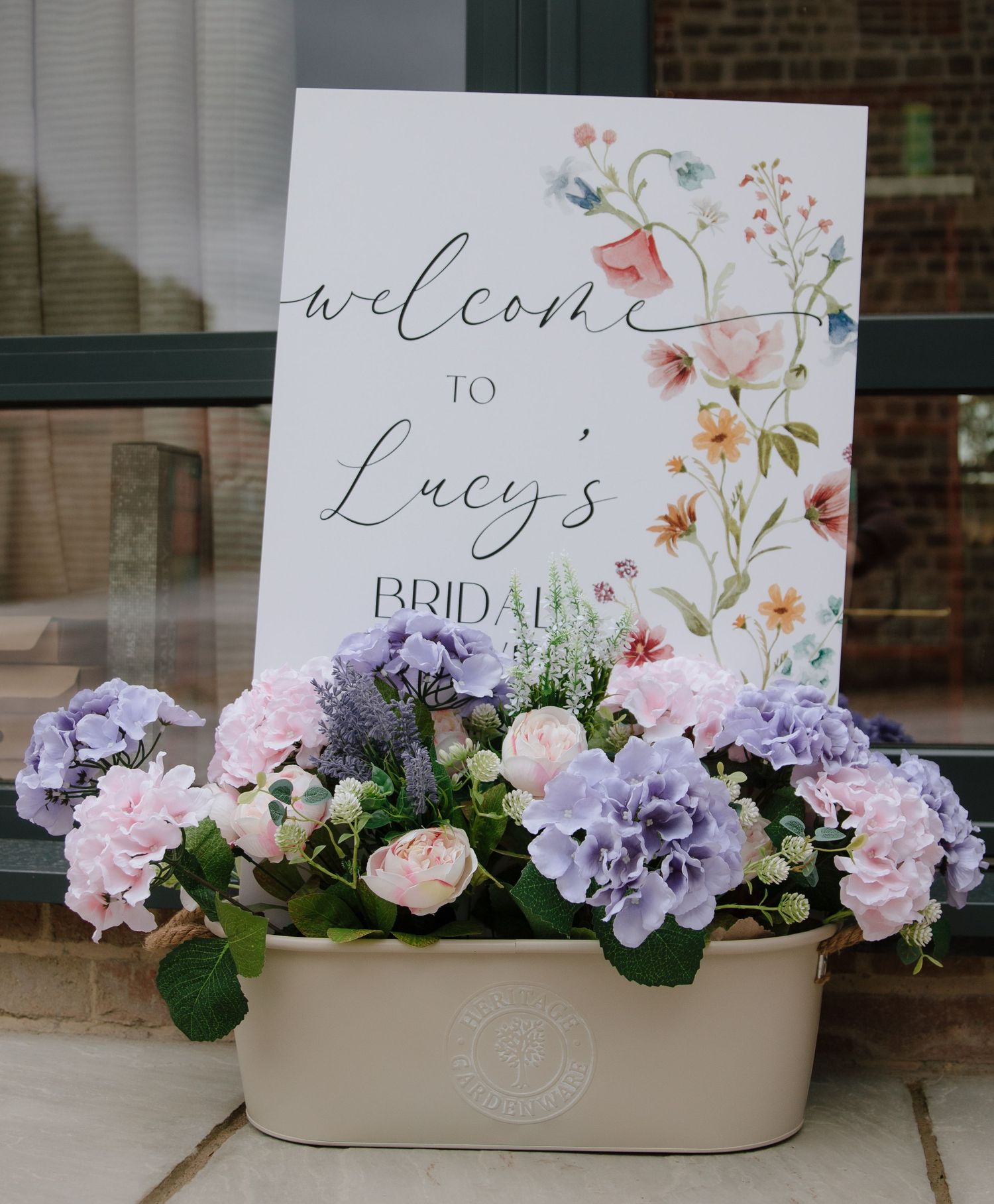 Wedding welcome display featuring pastel flowers and elegant calligraphy signage.