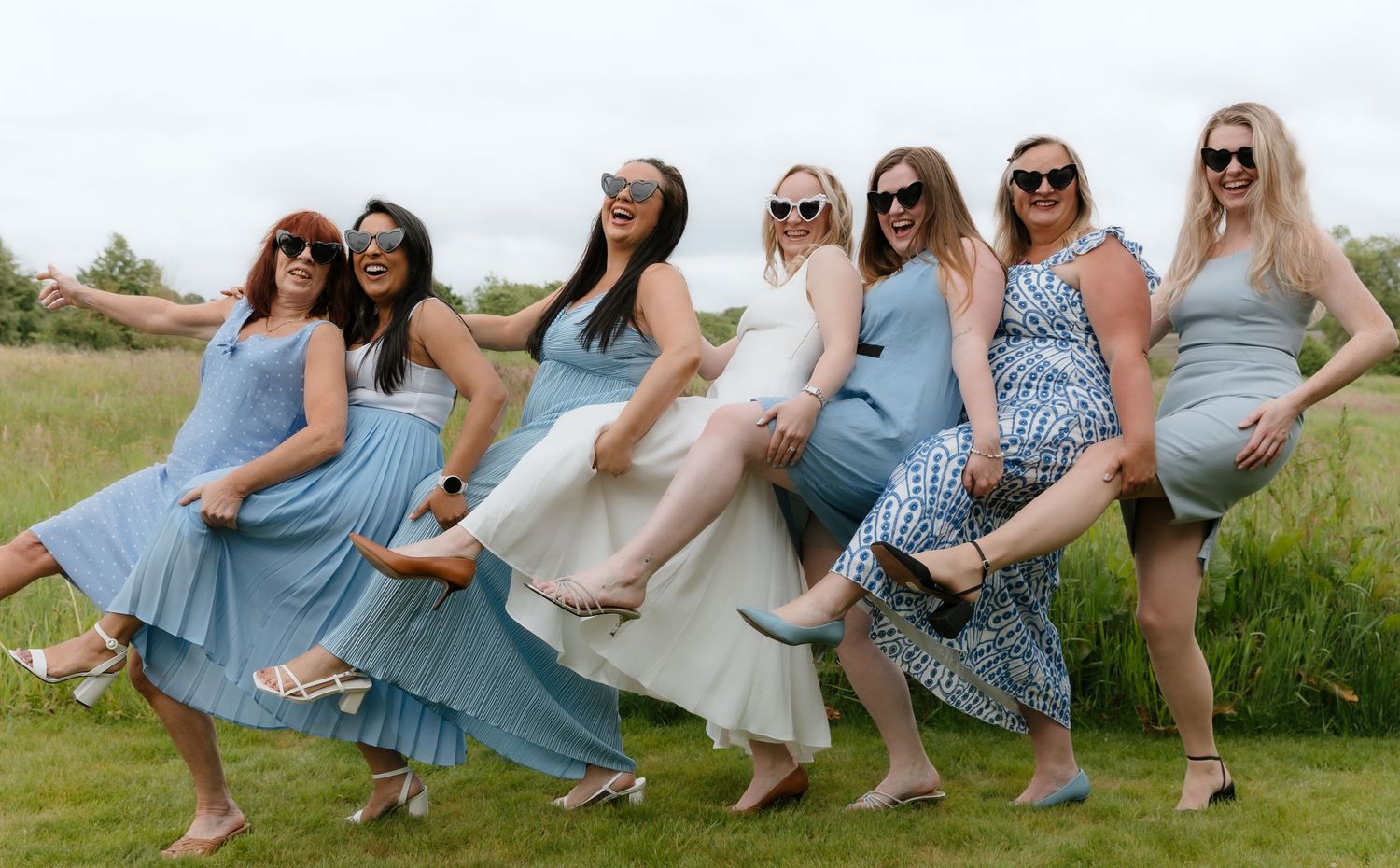 Ladies wearing coordinated blue and white outfits sit together on garden steps.