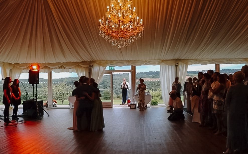 Large elegant wedding tent interior with chandeliers and dance floor.