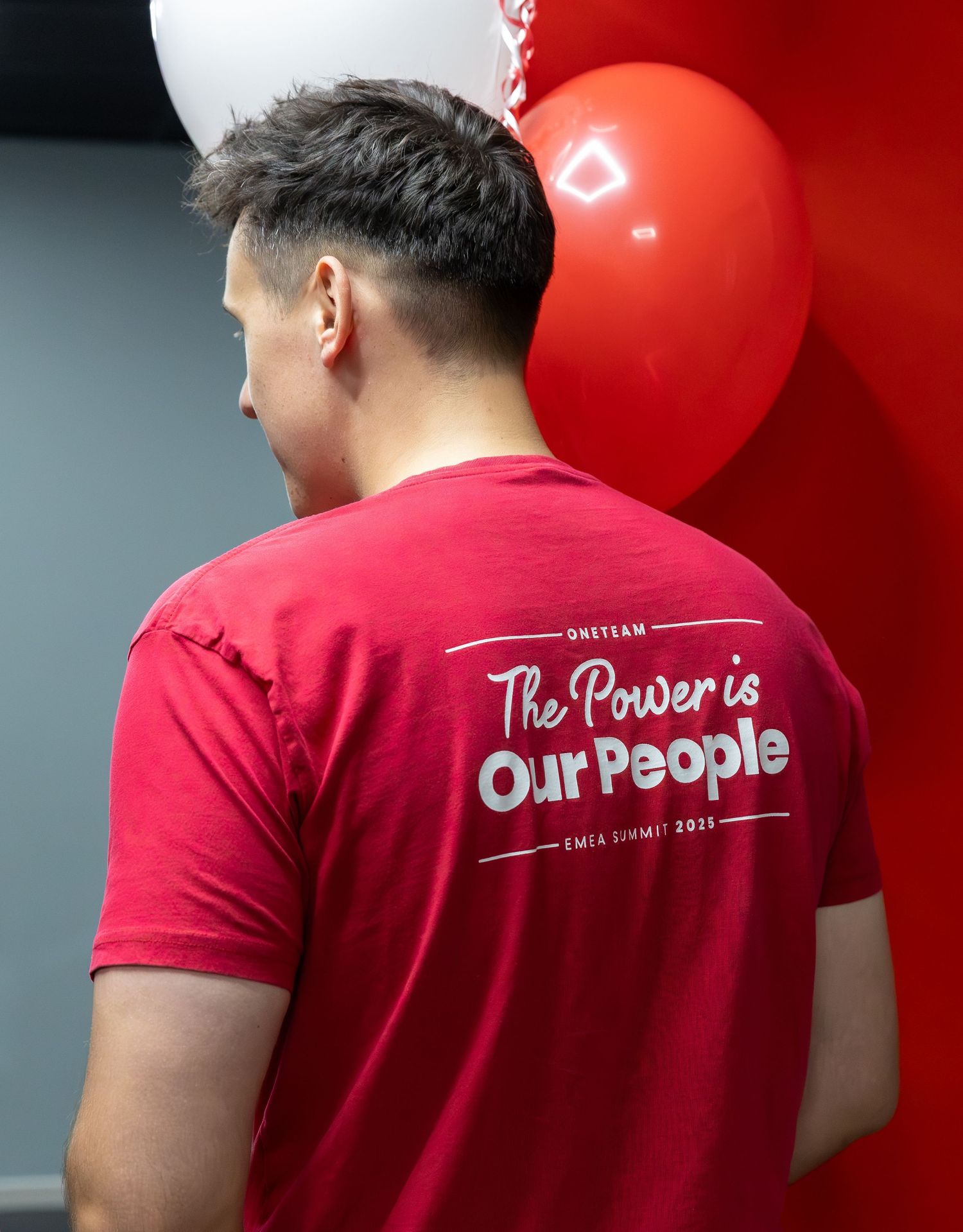Red t-shirt with 'Our People' text displayed on back in white lettering.