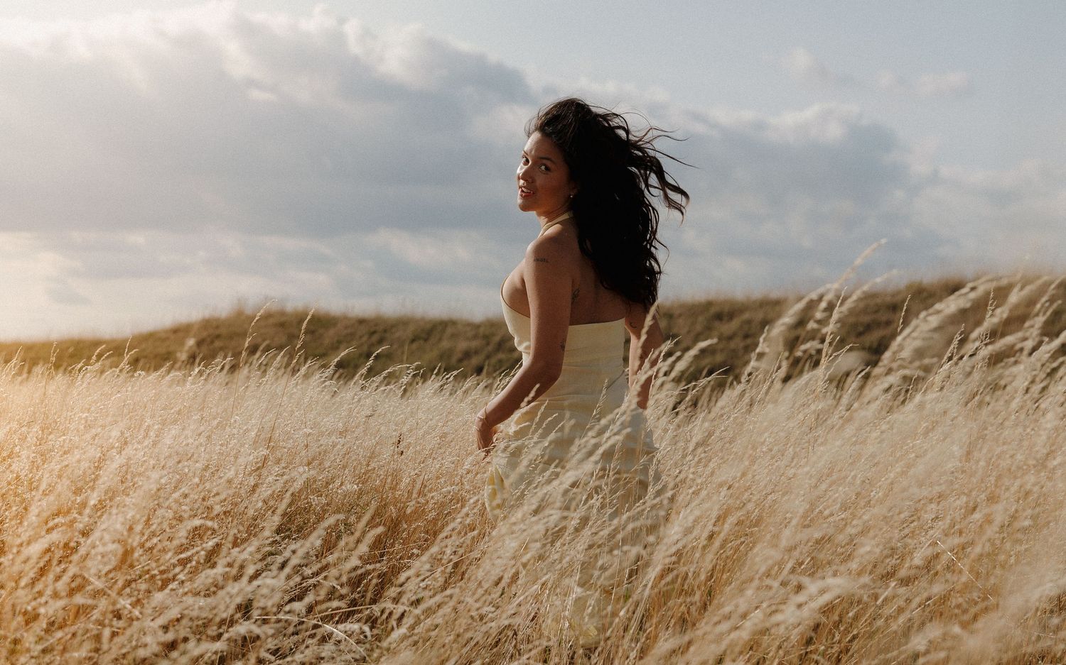 Scenic view of golden wheat field with person walking through tall grass.