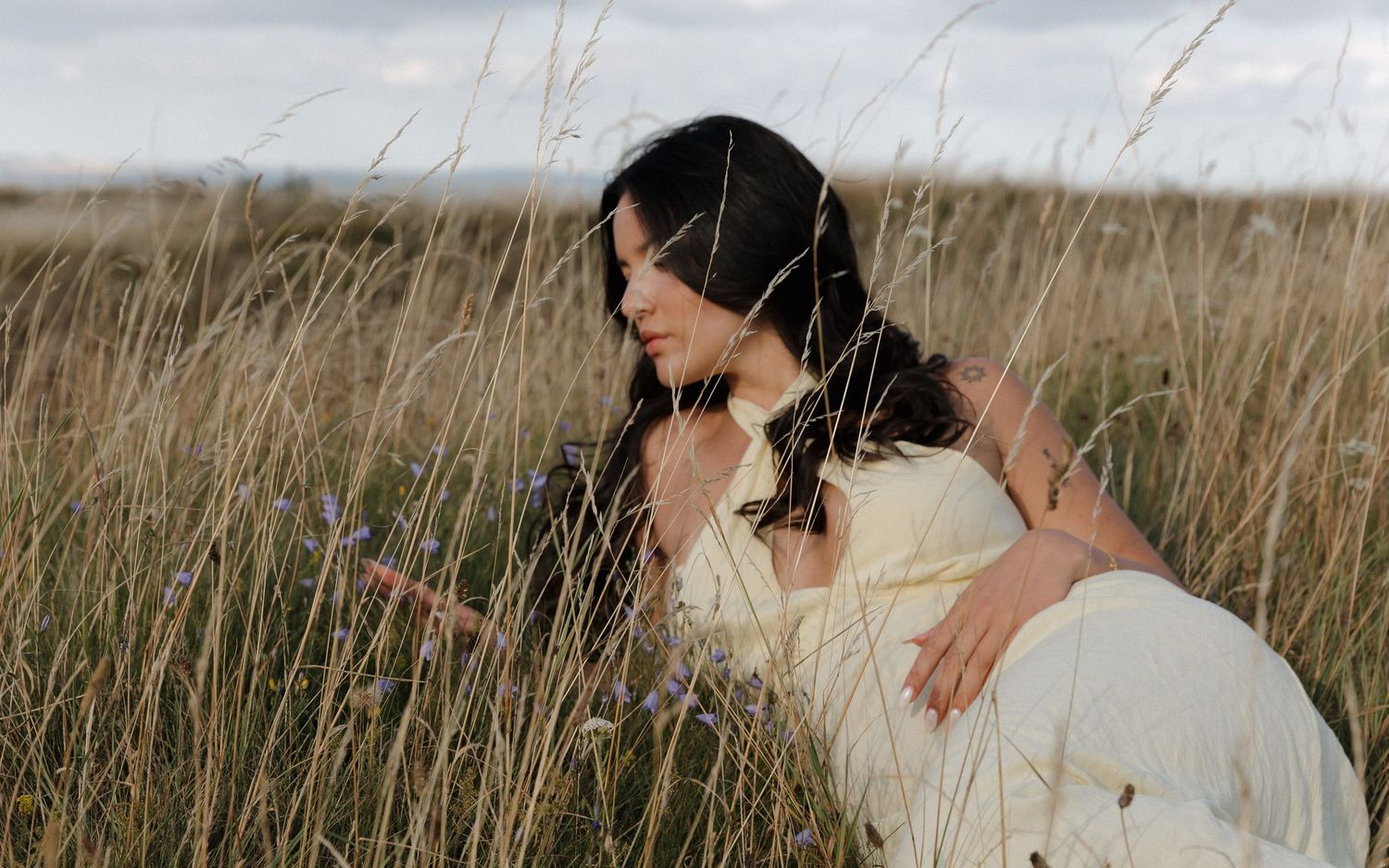 Ethereal portrait in wheat field with soft natural lighting and flowing movement.
