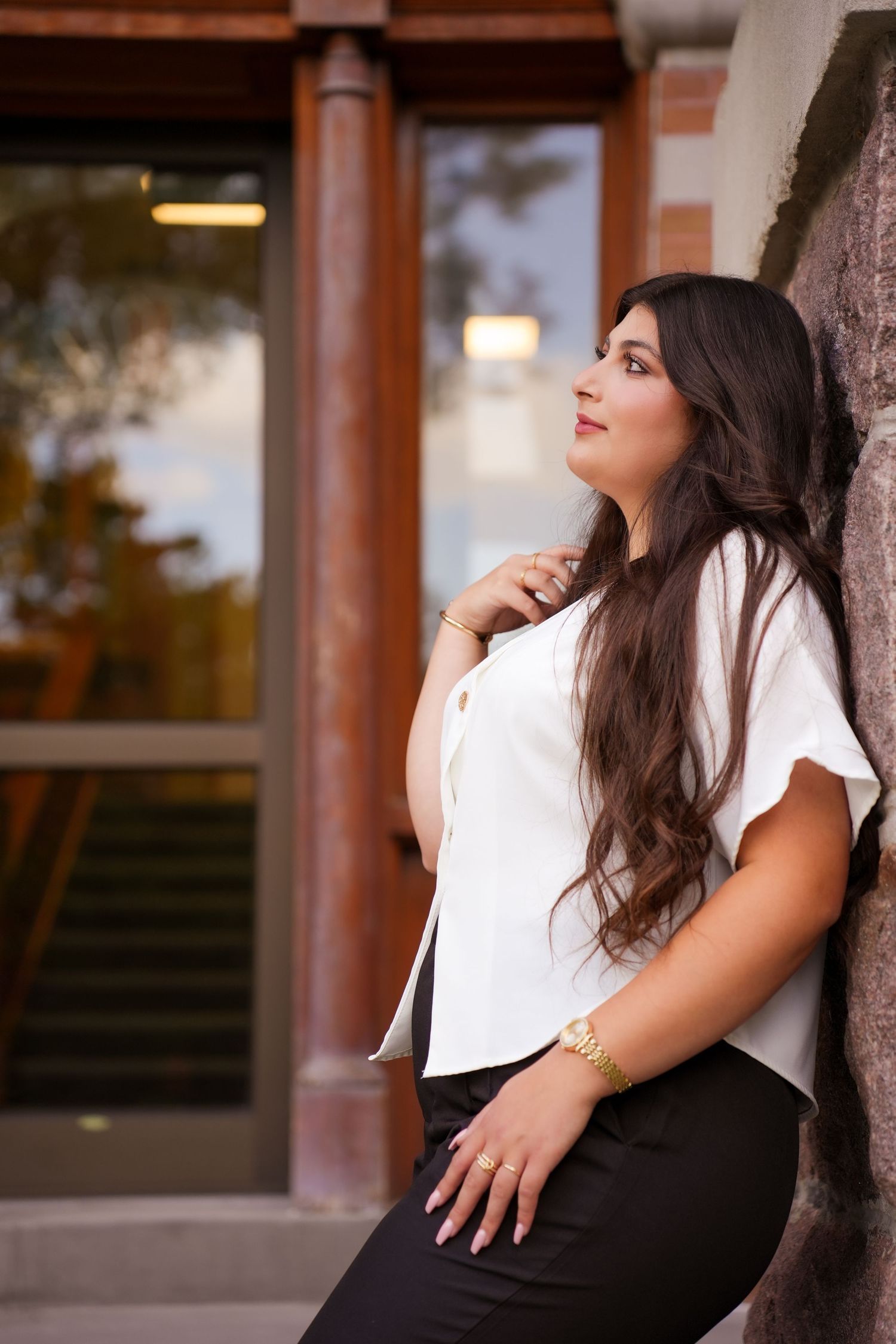 A person in black and white attire poses against a brick wall in an artistic portrait series.