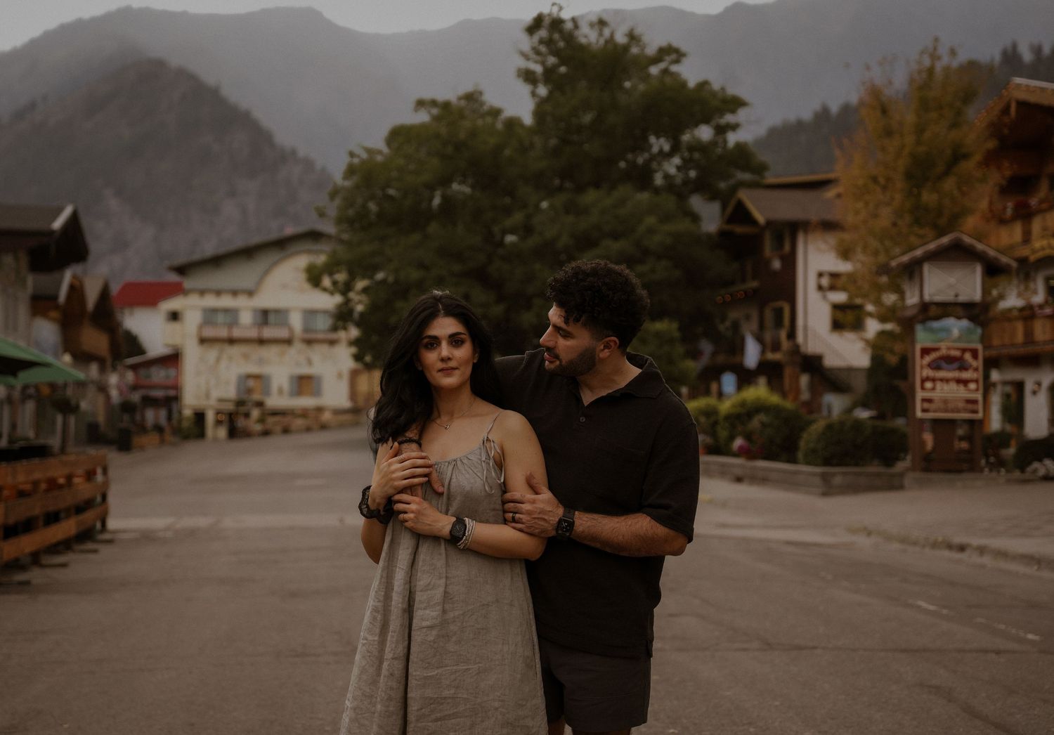 Couple strolling through a mountain town during golden hour.