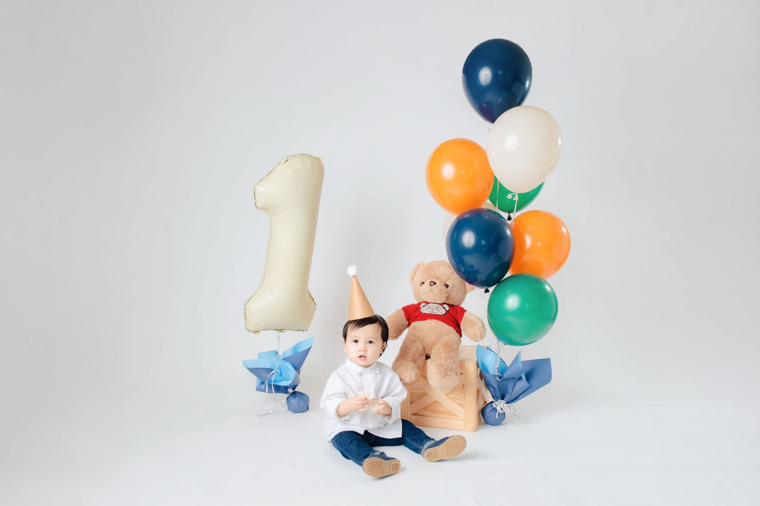 Colorful balloons and paper clouds create a whimsical floating scene against a light gray background.