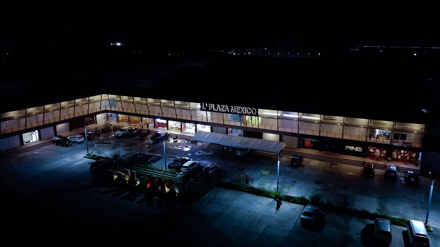 Panoramic view of a dimly lit warehouse interior with windows and industrial shelving.