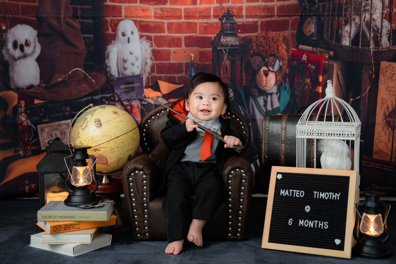A magical Harry Potter inspired photo setup with antique props, books, and a leather armchair.
