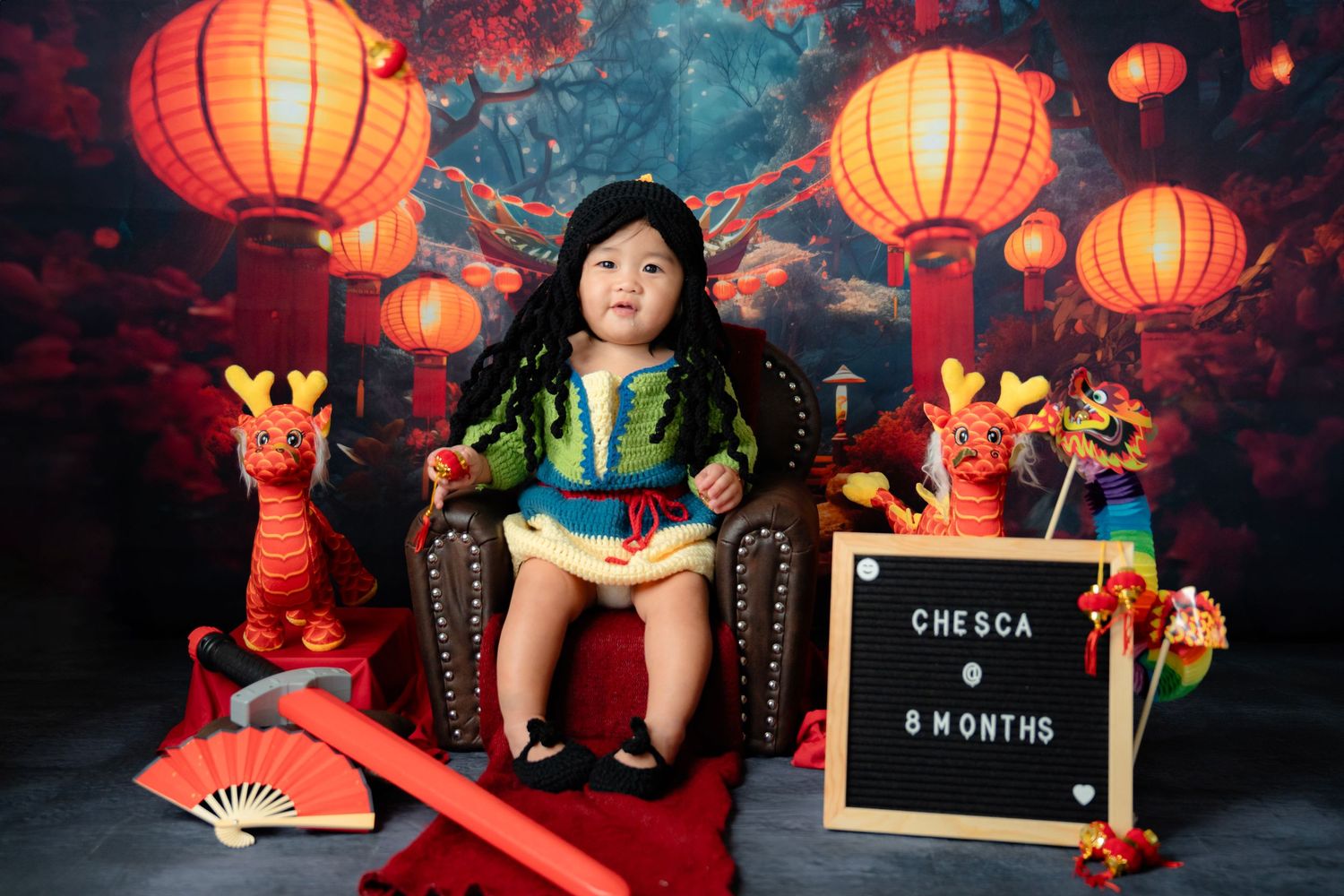 Asian inspired photo session with red paper lanterns and traditional decorative elements.