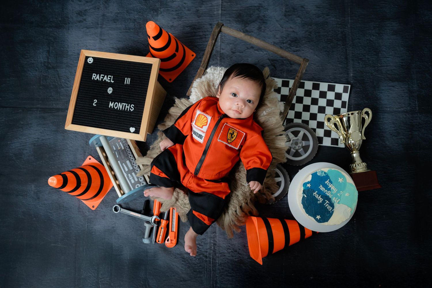 Race car themed photo setup with orange traffic cones and checkered flag accessories.