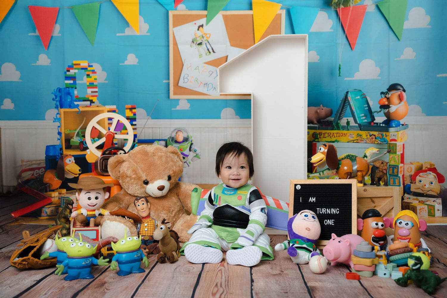 Playful toy story themed photo setup with stuffed animals and character props against blue background.