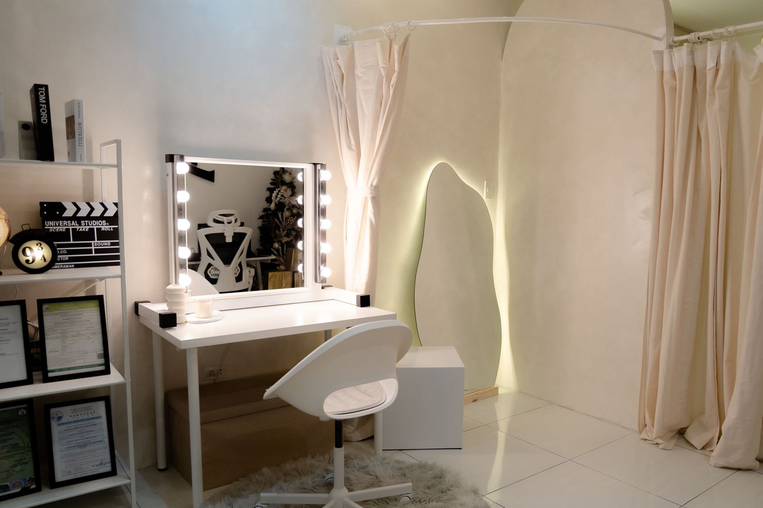 Modern vanity setup with illuminated mirror and white furniture in a minimalist room setting.