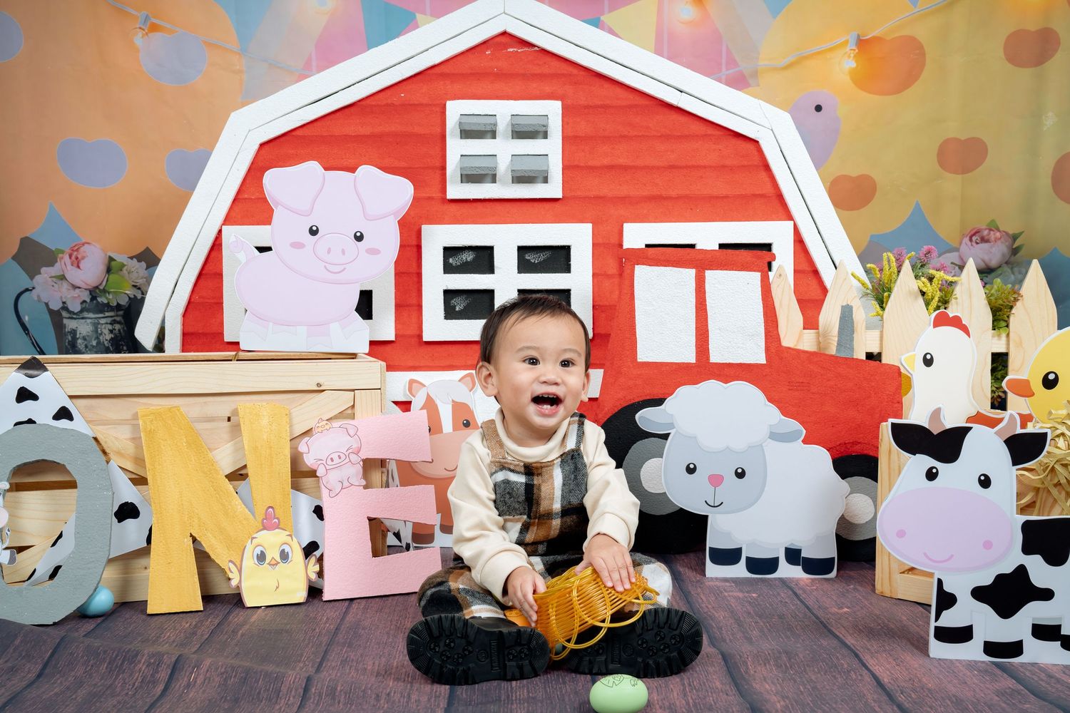 Red barn themed photography backdrop with farm animals and rustic decorations.
