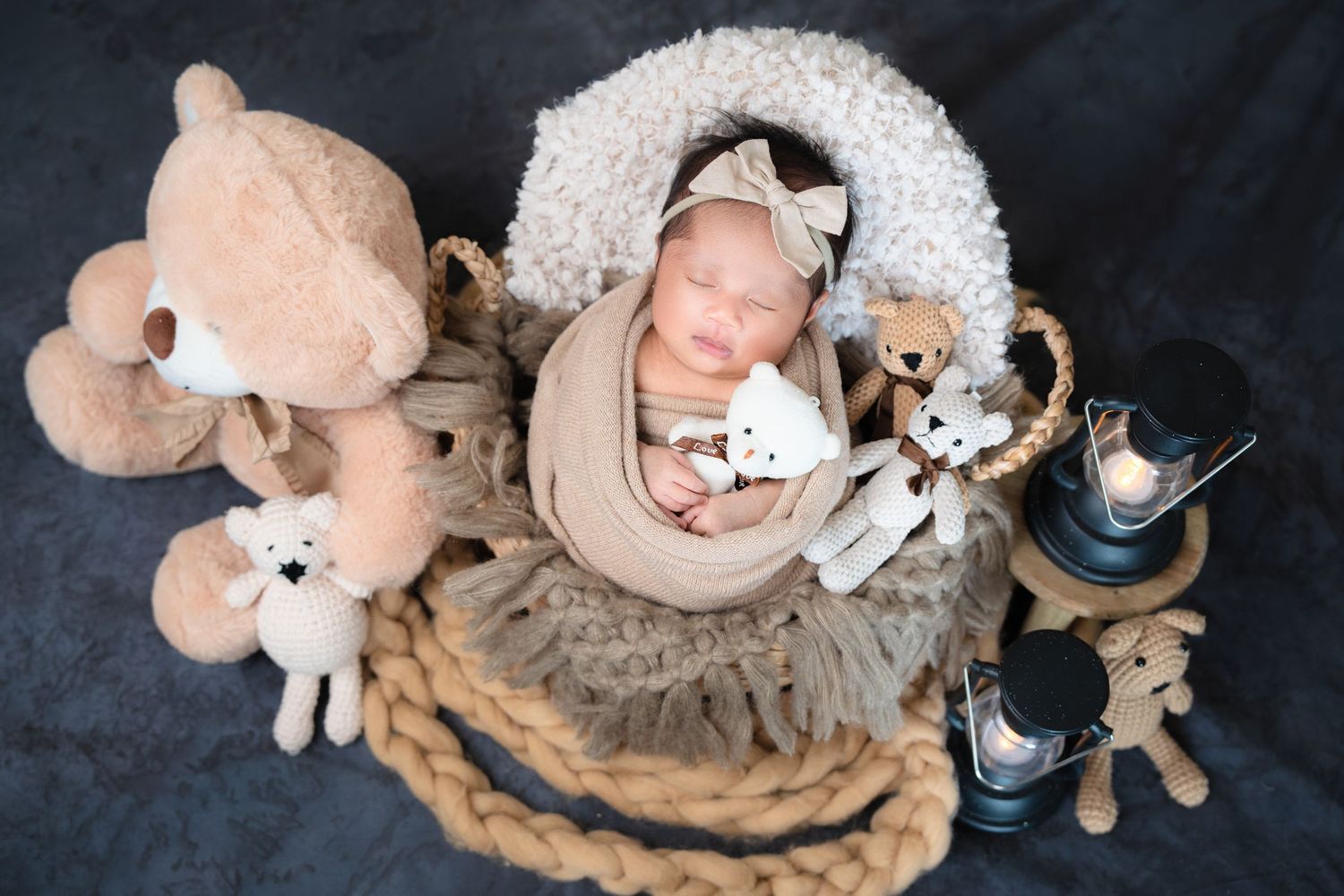 Overhead view of sleeping baby with stuffed animals and vintage decor on textured circular mat.