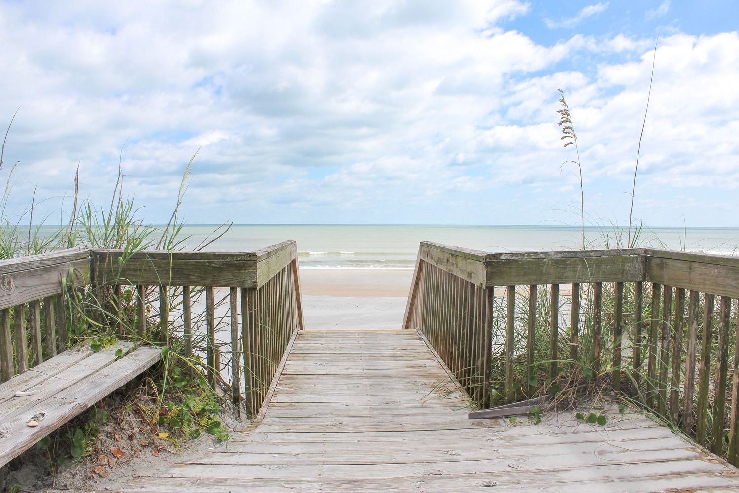 Beautiful photograph of a beachside dock with ocean and sky.