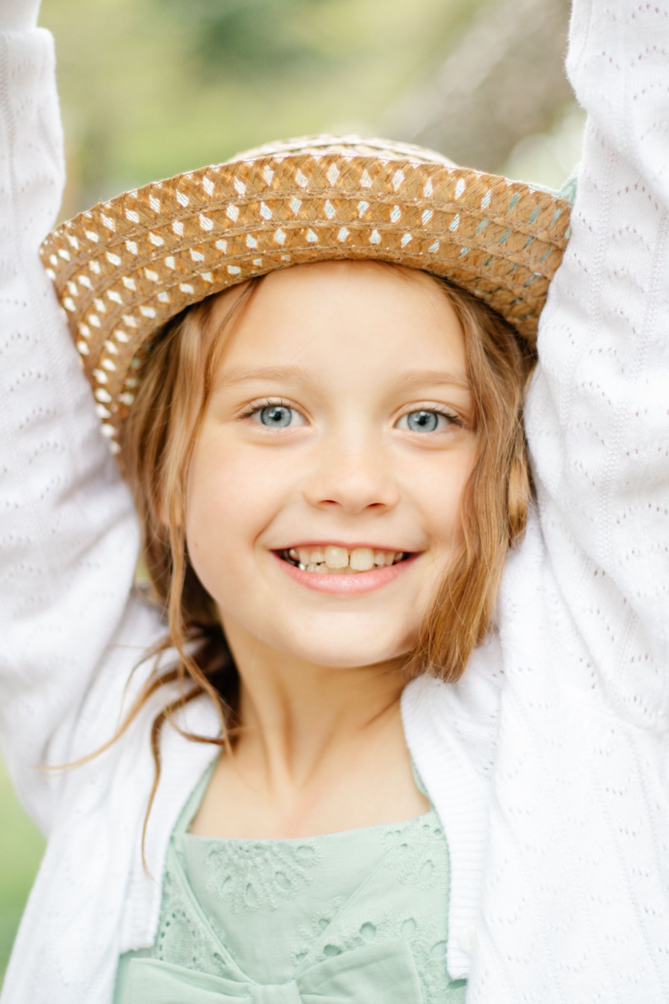 Sweet expressions in sequence wearing mint green dress and straw hat outdoors.