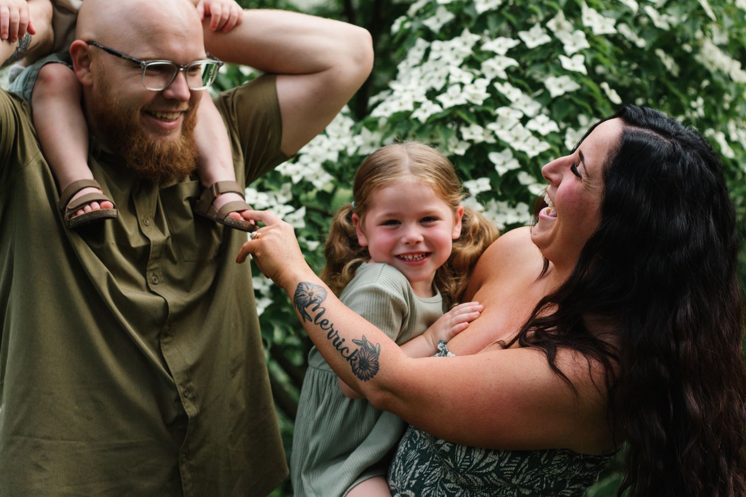 Playful outdoor family interactions against a backdrop of green foliage.