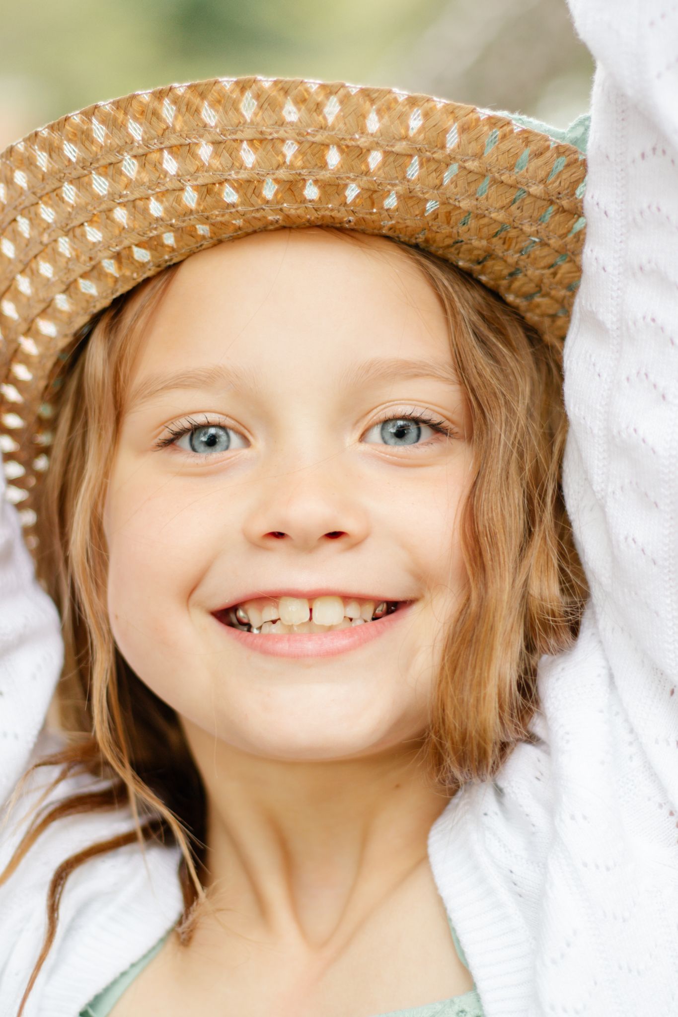 Sequence of close-up shots showing bright blue eyes under a woven straw hat.