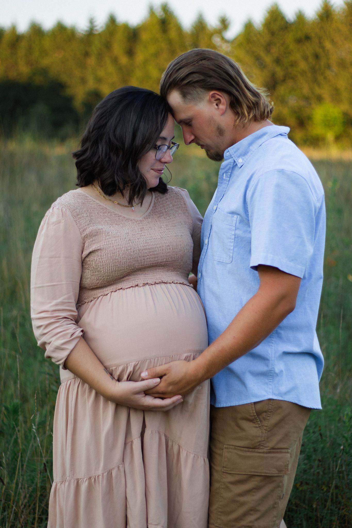 Intimate maternity photography session with couple in a scenic outdoor setting.