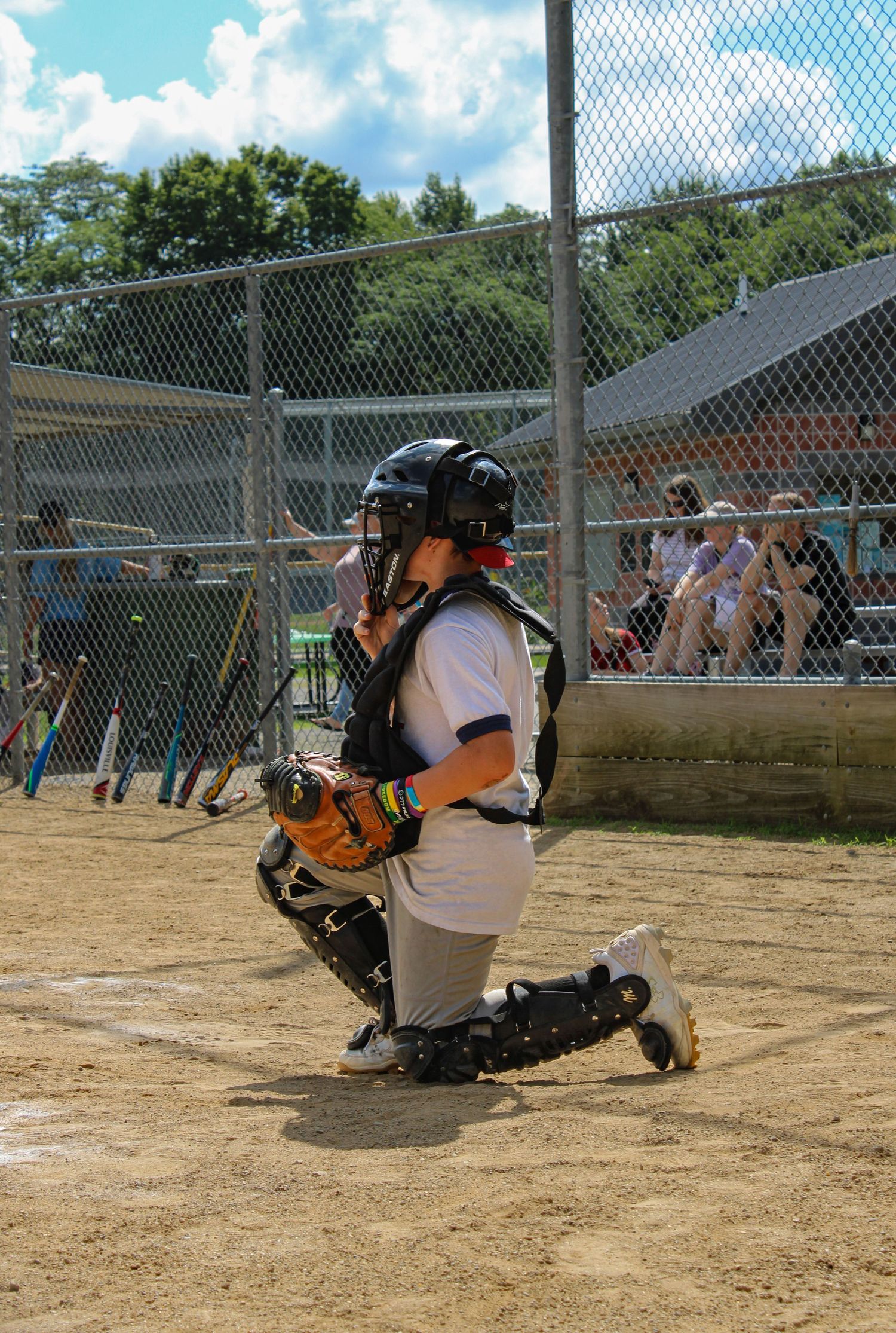 Baseball catcher demonstrating proper blocking technique on dirt field.