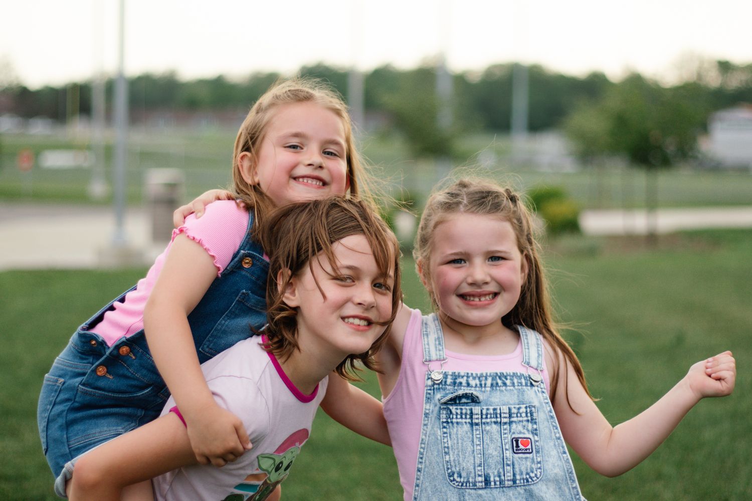 Group lounging and laughing together on green grass during summer day.