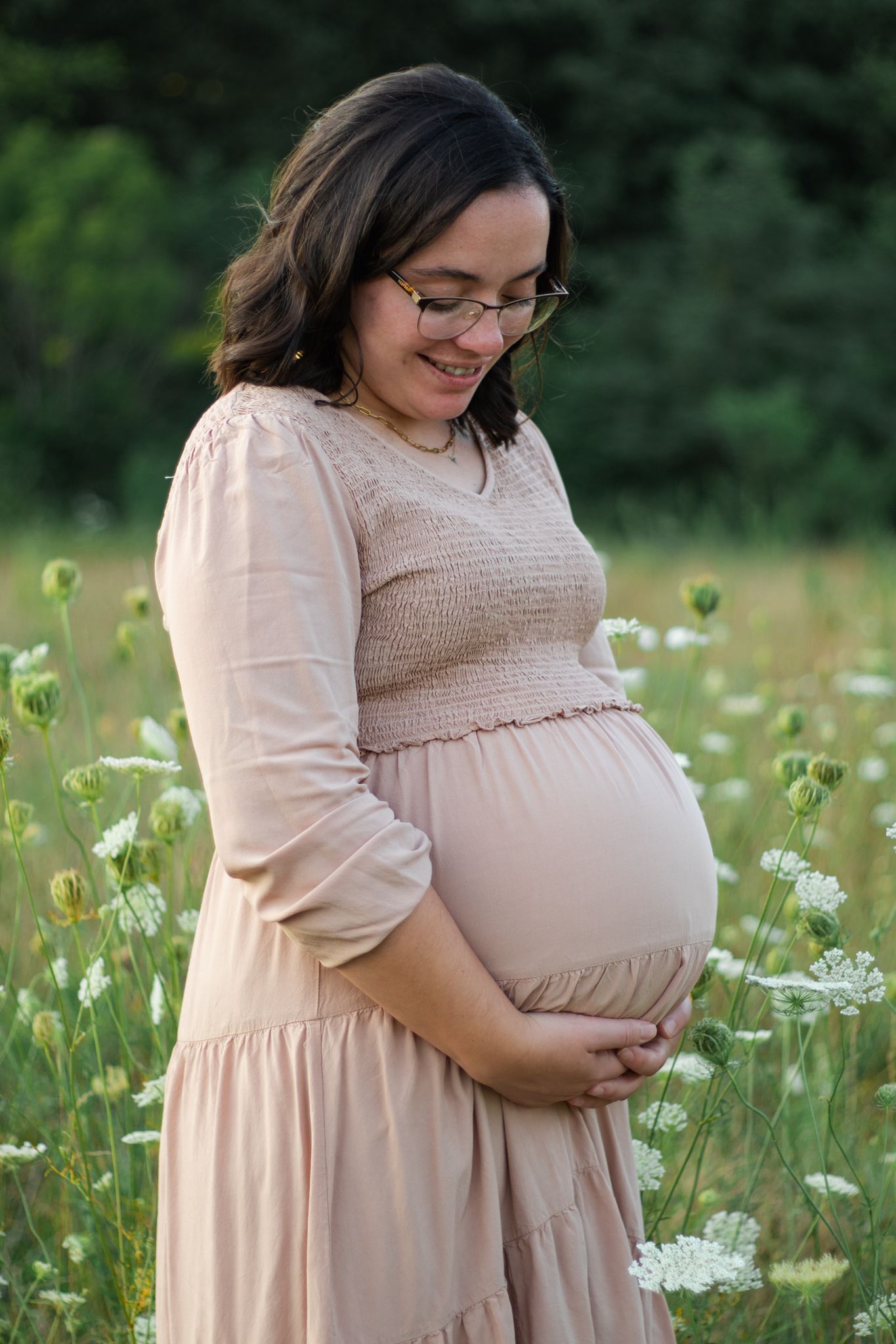 Beautiful maternity portraits taken in a wildflower field during golden hour.