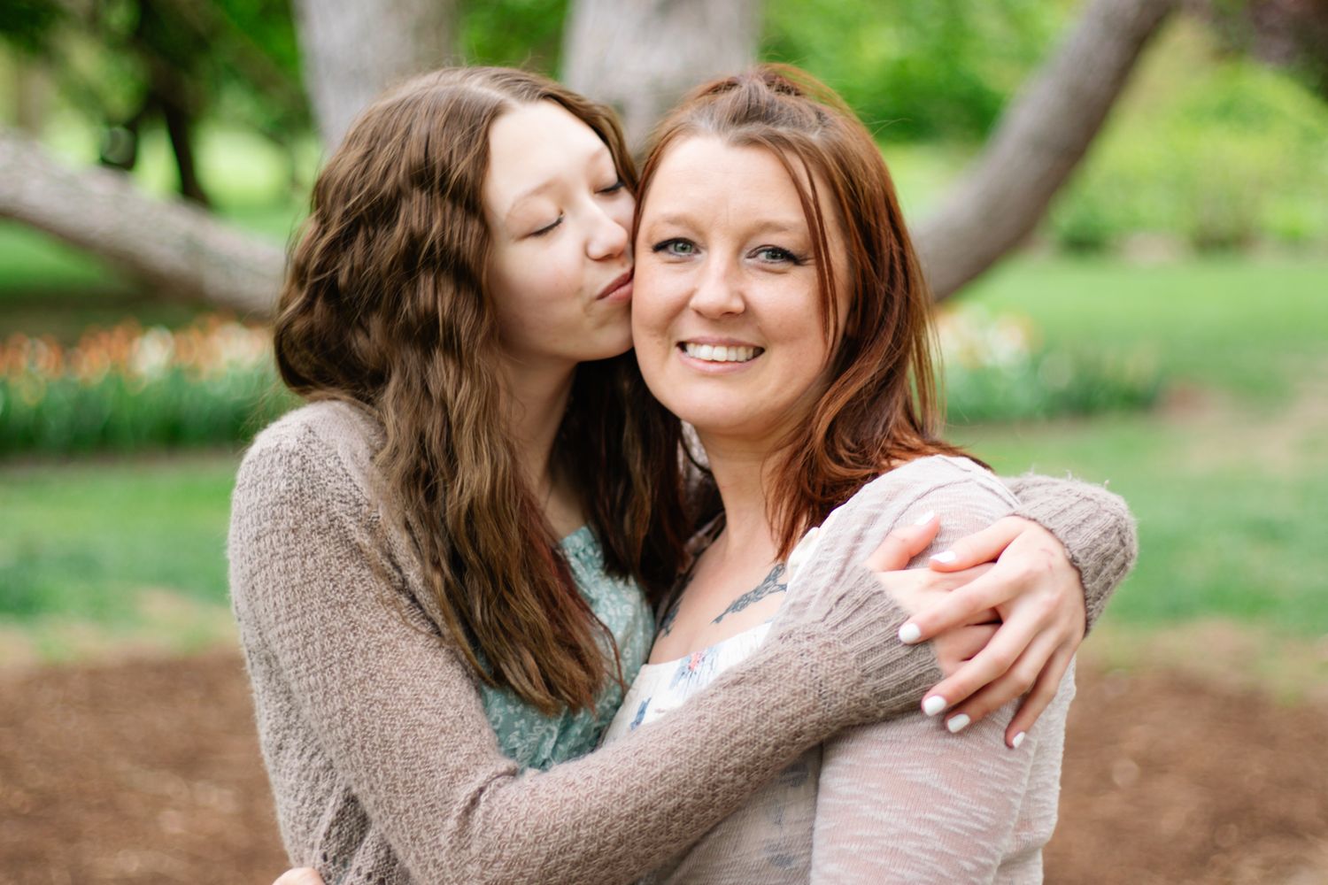 Candid embrace captured in a serene garden setting during springtime.