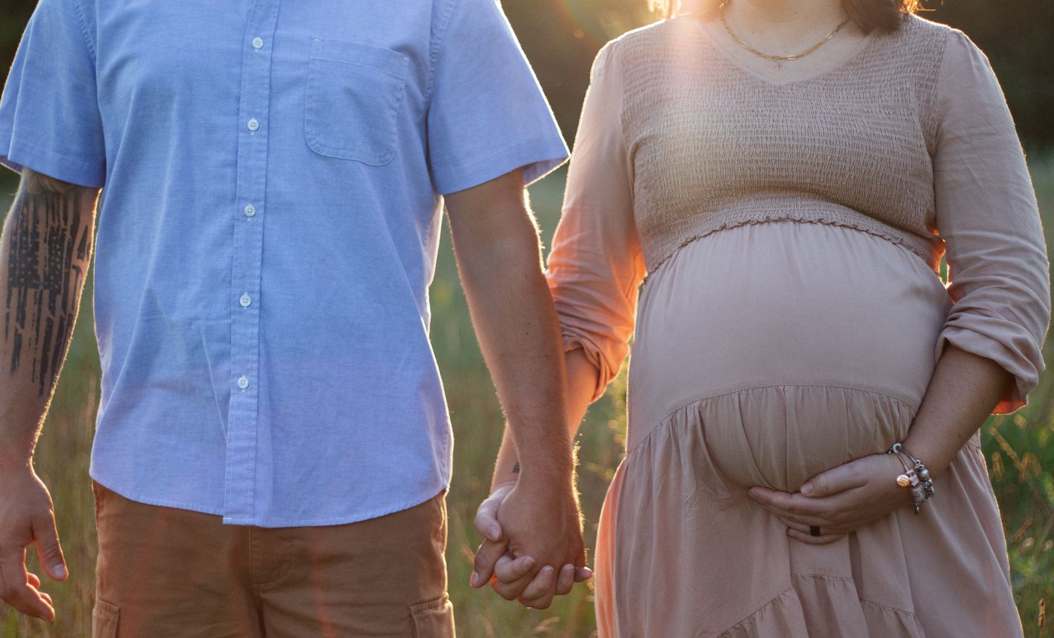 Couple's maternity photos showing tender moments in natural outdoor setting.