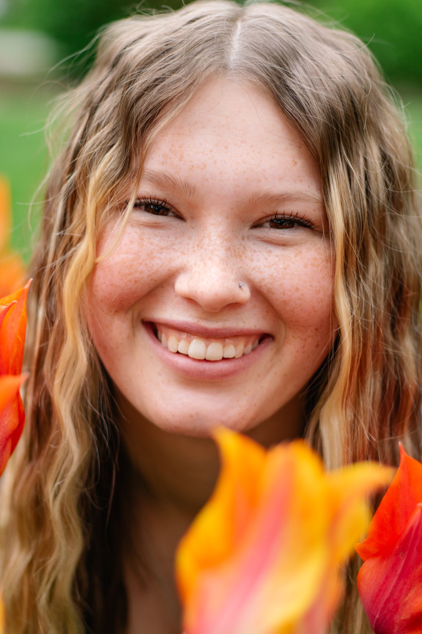 Close-up portrait transitions with vibrant orange tulips in the foreground.