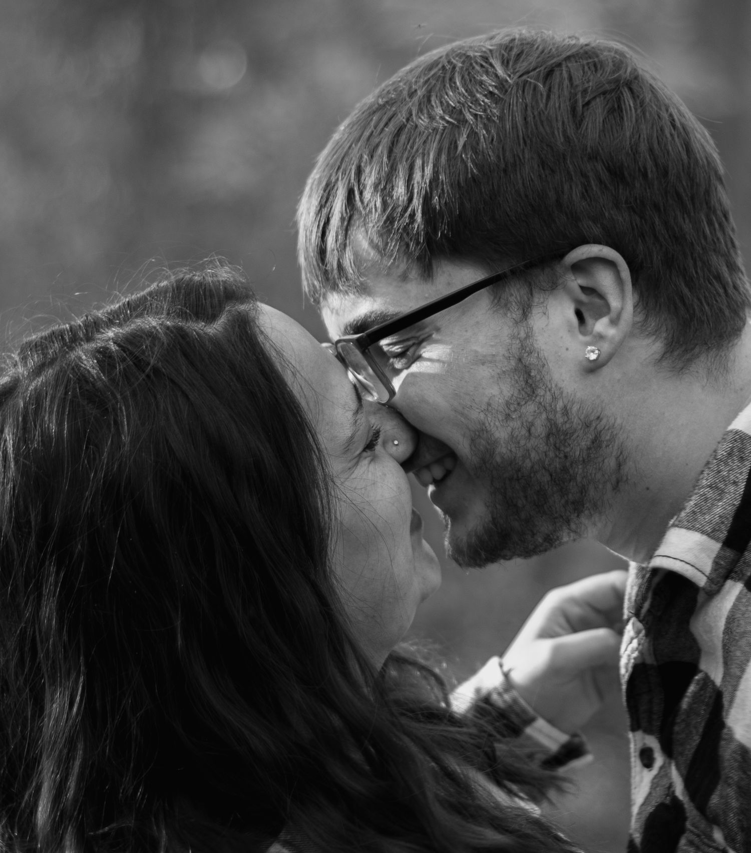Black and white intimate portrait of a couple sharing a romantic close-up moment.