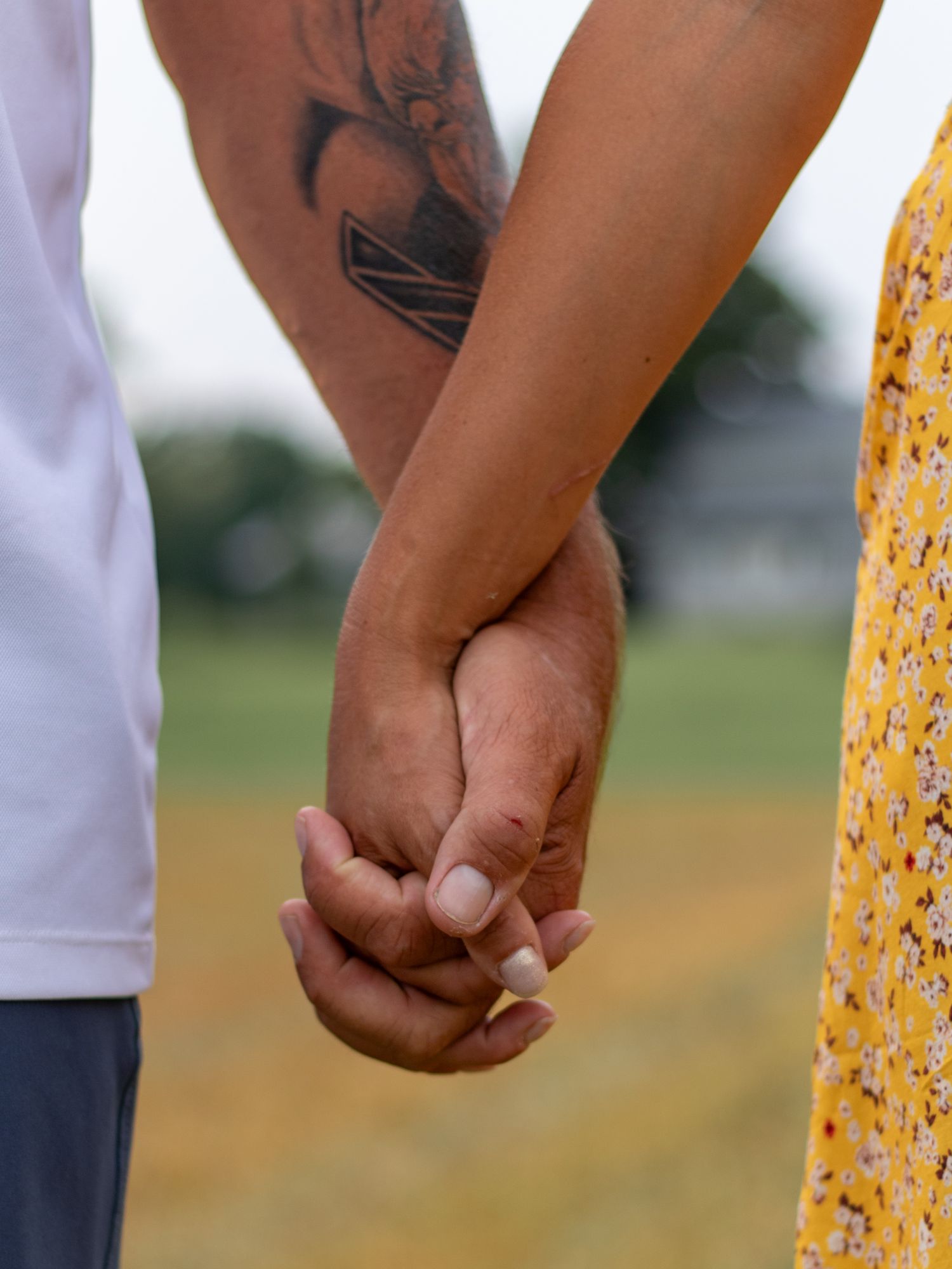 Close-up shots of hands holding together showing tattoo details.