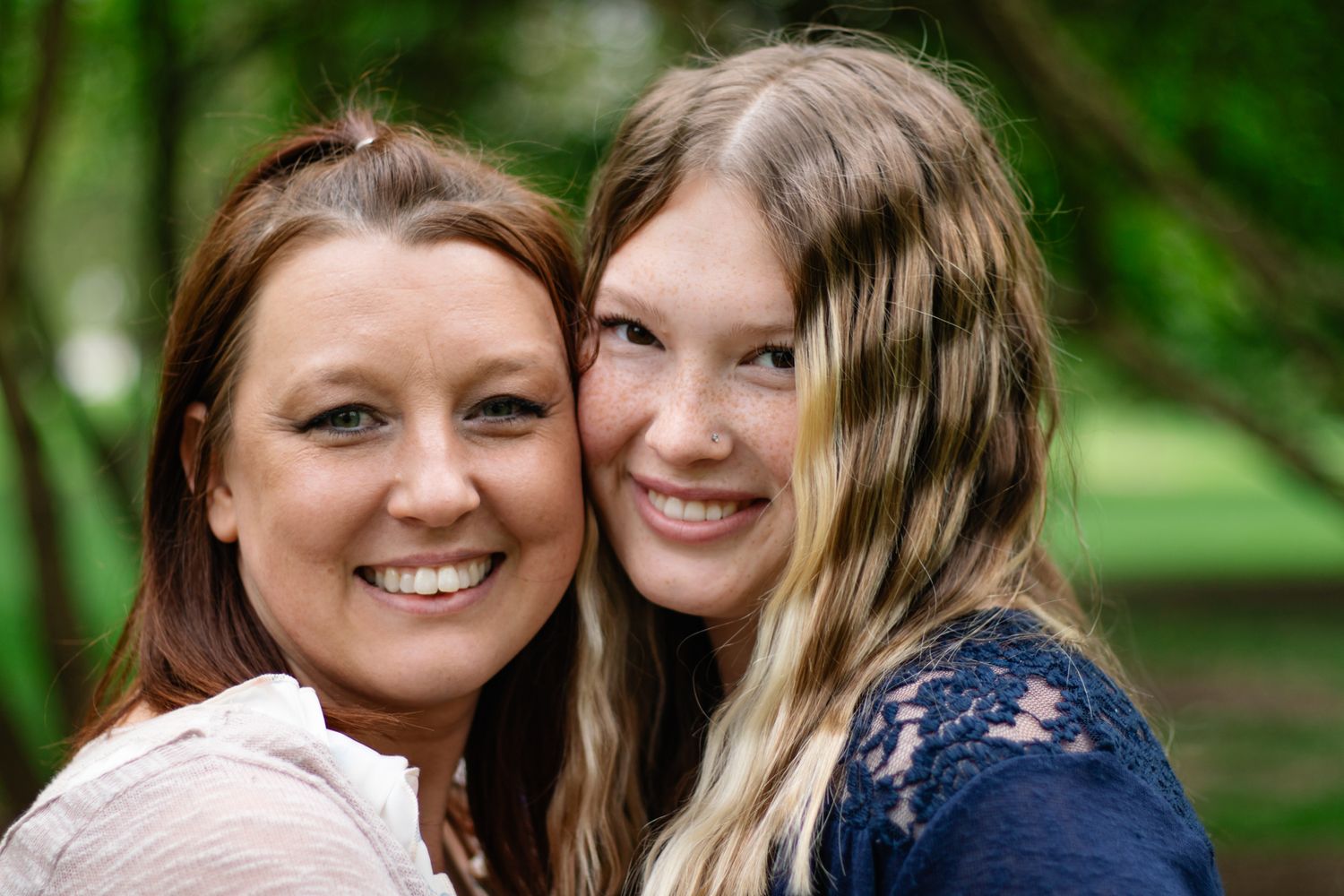 Family members sharing warm embraces during outdoor portrait session.