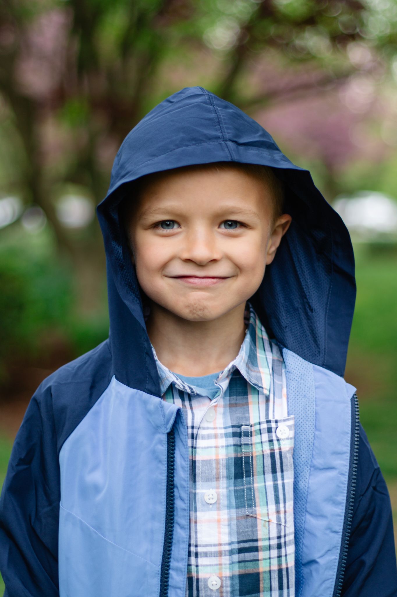 A sequence of photos showing a child wearing a navy blue hoodie and plaid shirt smiling at the camera outdoors.