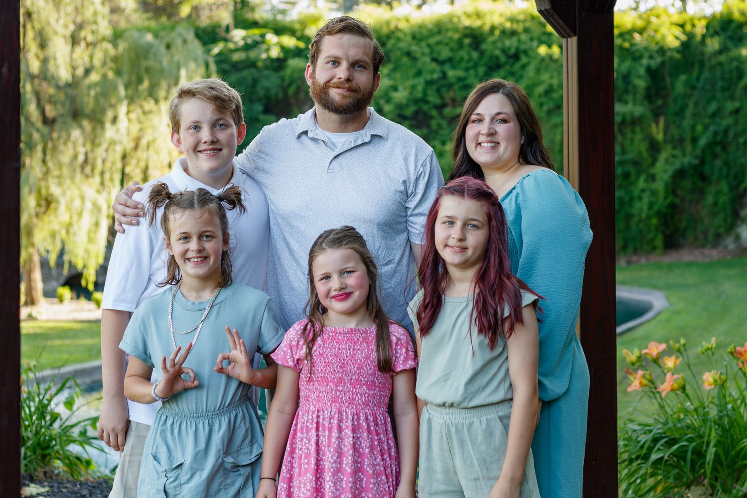 Happy family portrait with children in coordinated pastel outfits.