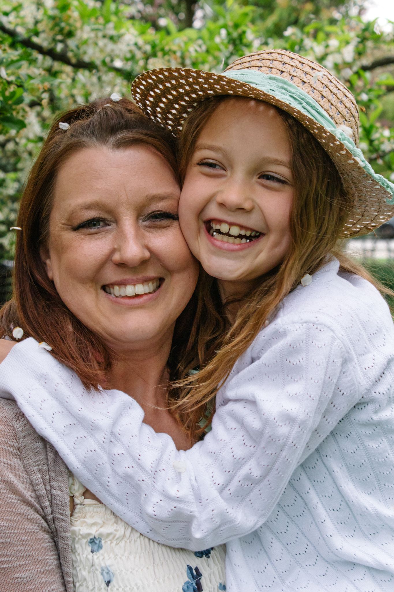 Sweet outdoor portrait wearing white eyelet clothing and straw hat in spring setting.