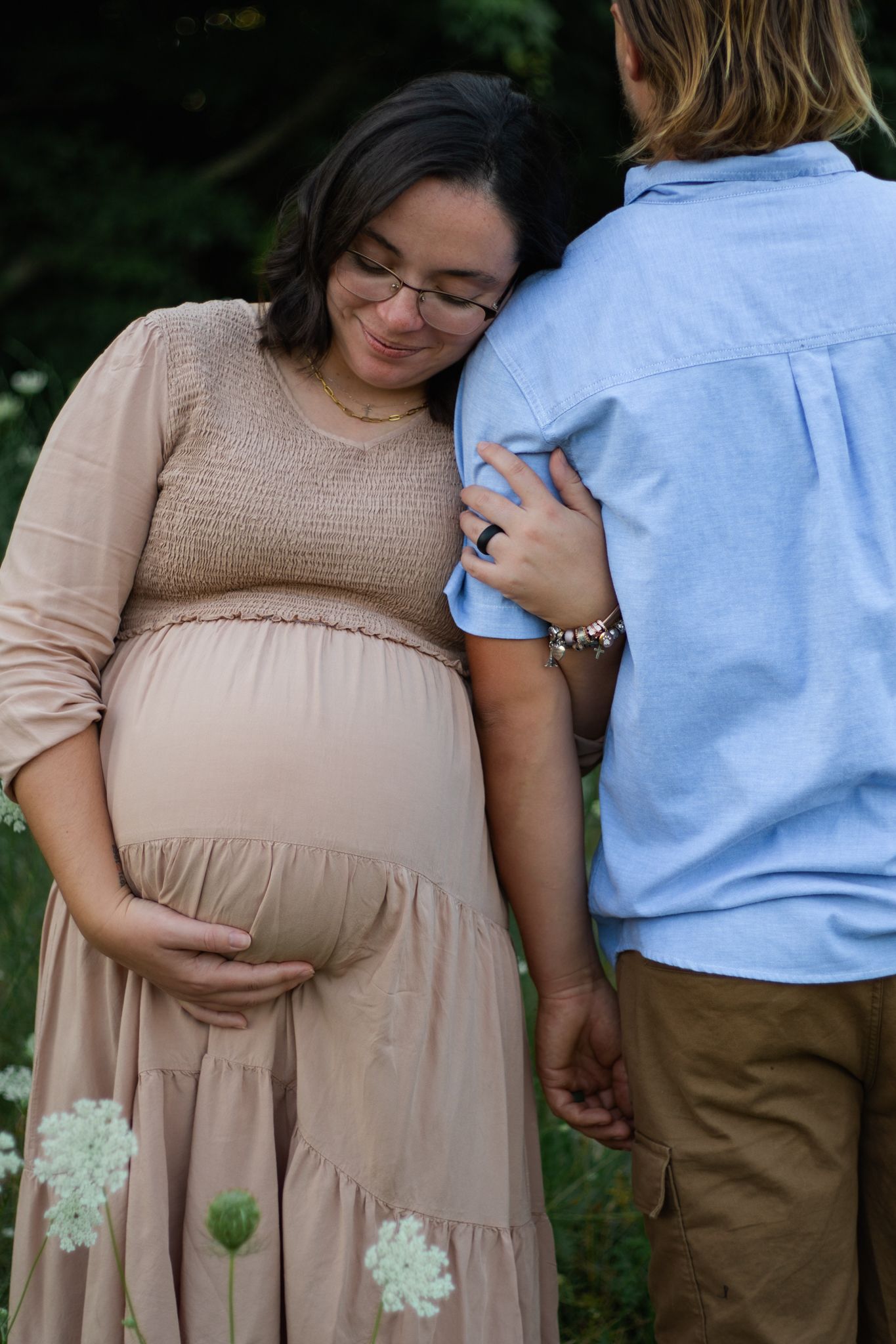 Sweet maternity session featuring couple among blooming Queen Anne's Lace flowers.