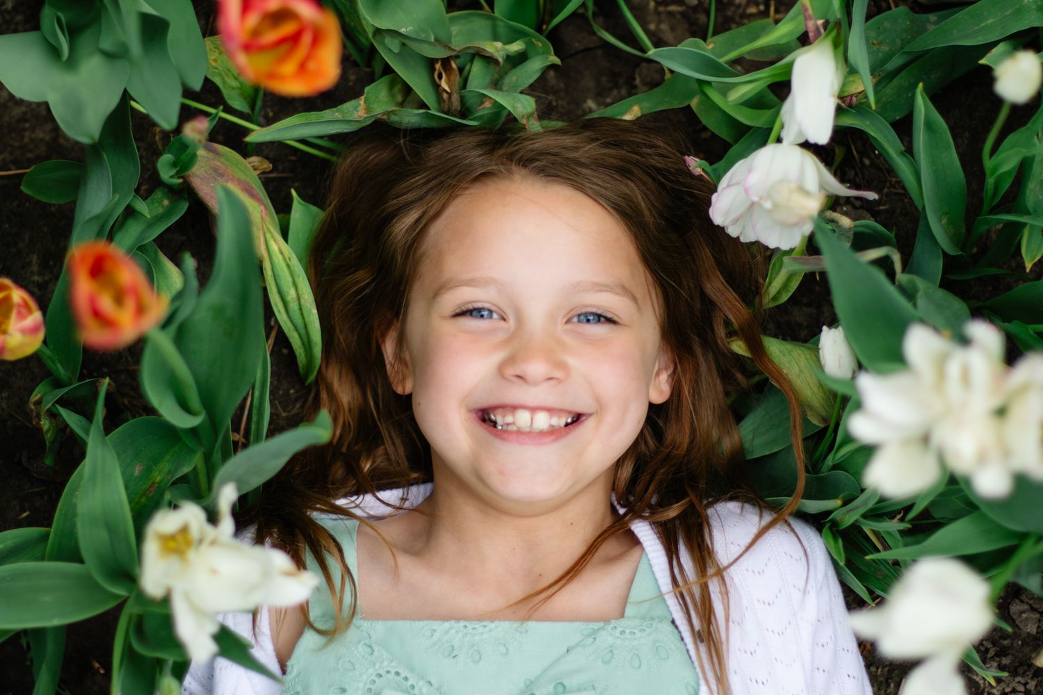 Portrait sequence surrounded by lush greenery and white flowers in a garden setting.
