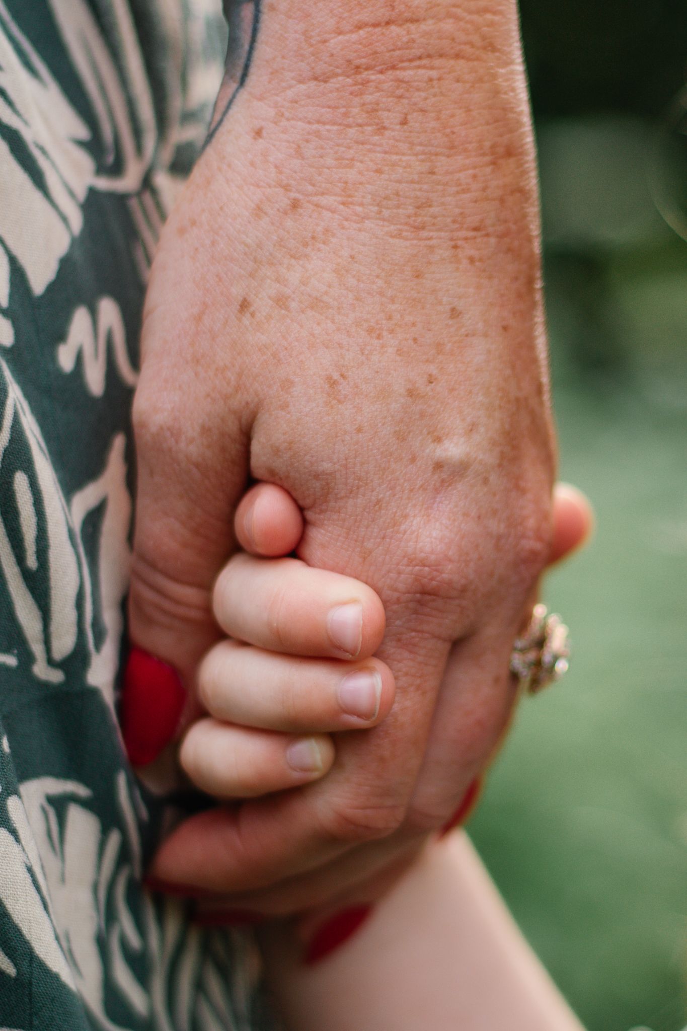 Close-up of hands clasped together showing tender family connection.