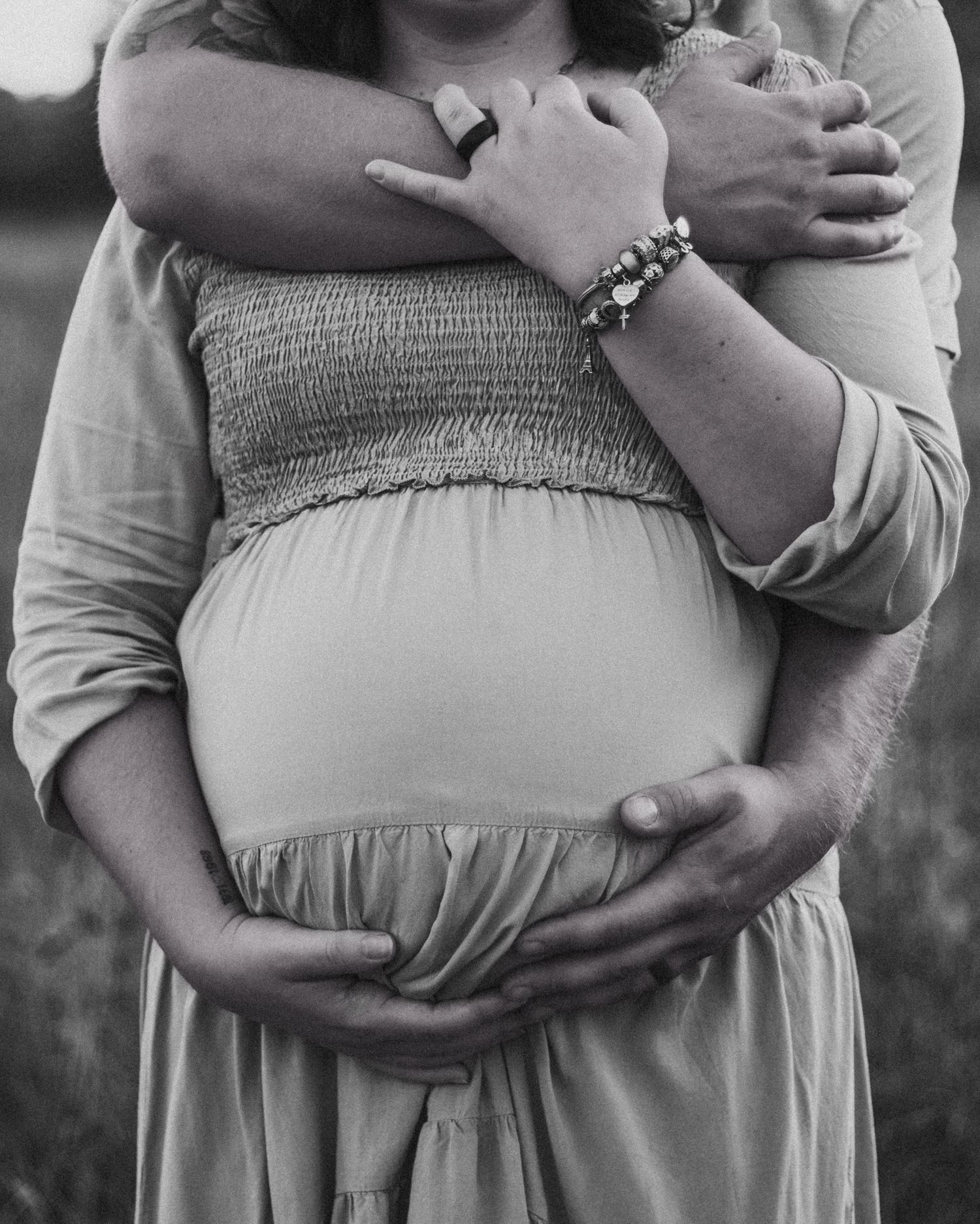 Black and white maternity photos showing tender moments between expectant parents.