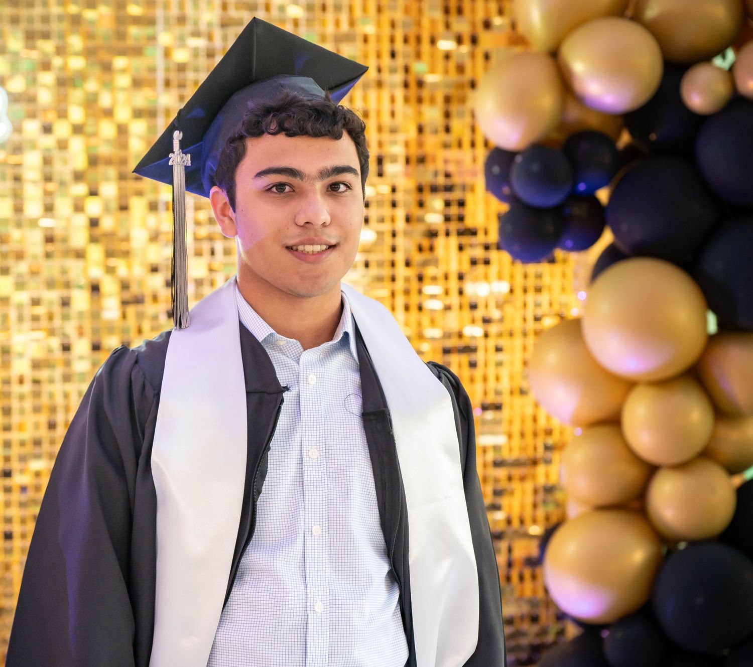 Graduation party portrait of a senior boy celebrating, photographed indoors with flash lighting by ek-framedmemories in Northern Virginia.