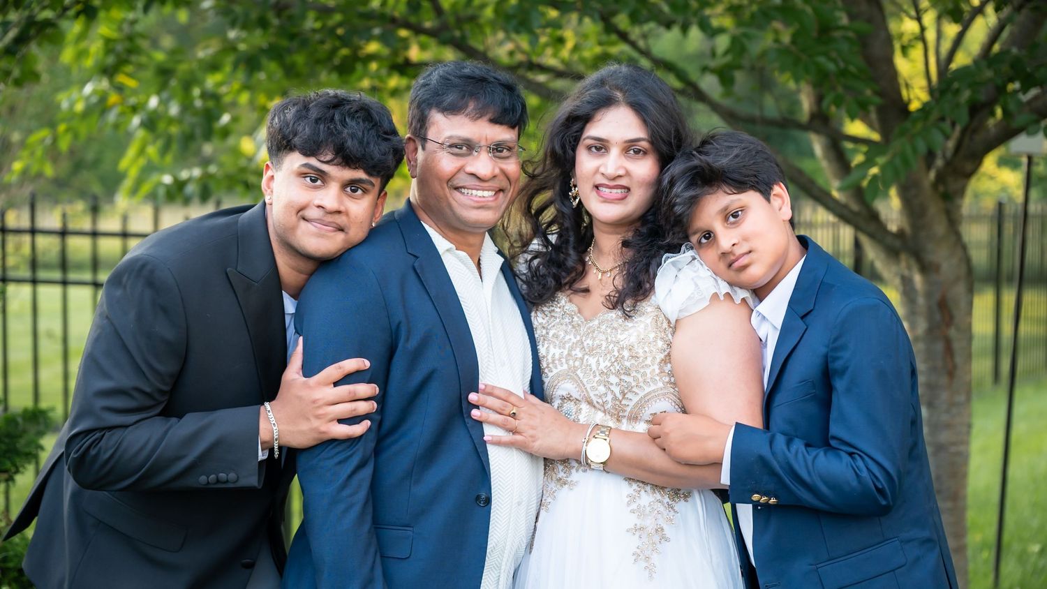 Family portrait with parents and two older boys in a relaxed outdoor session