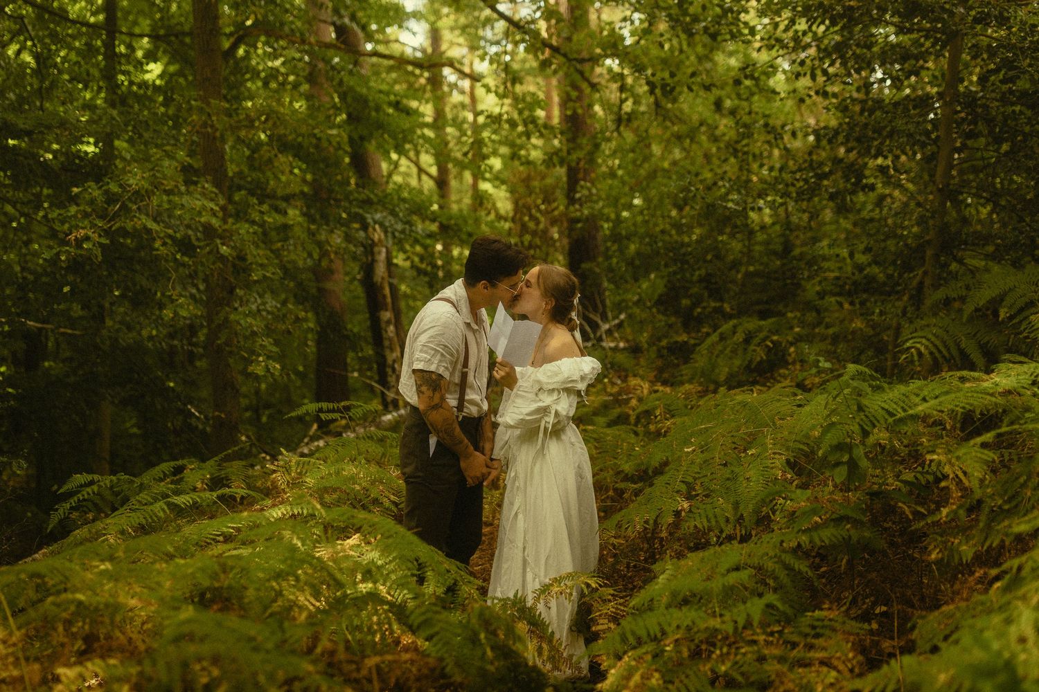 A romantic forest engagement photo session with soft golden sunlight filtering through lush green trees.