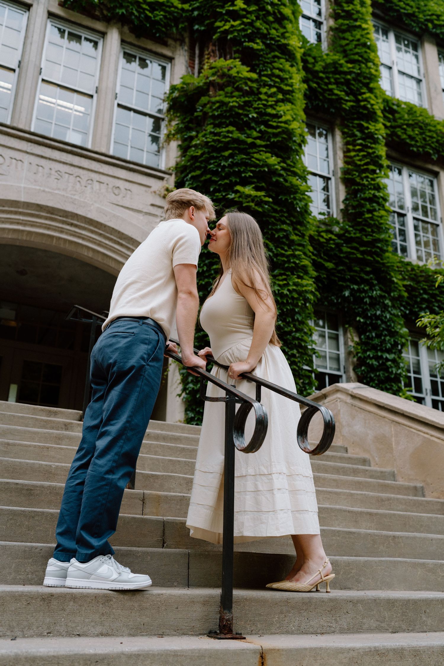 Romantic moment on ivy-covered building steps with vintage architecture.